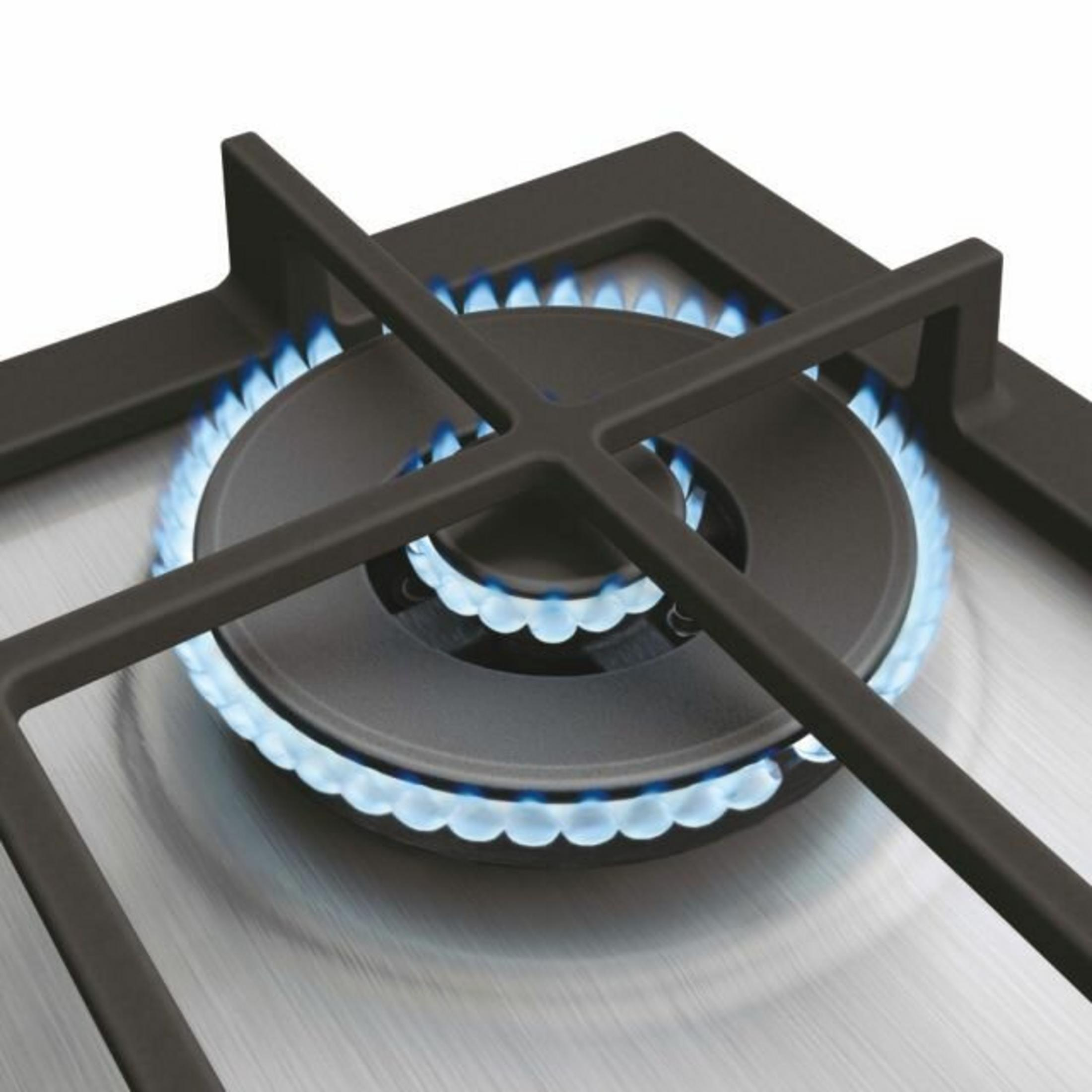 Palnik gazowy z niebieskim płomieniem na metalowej płycie.