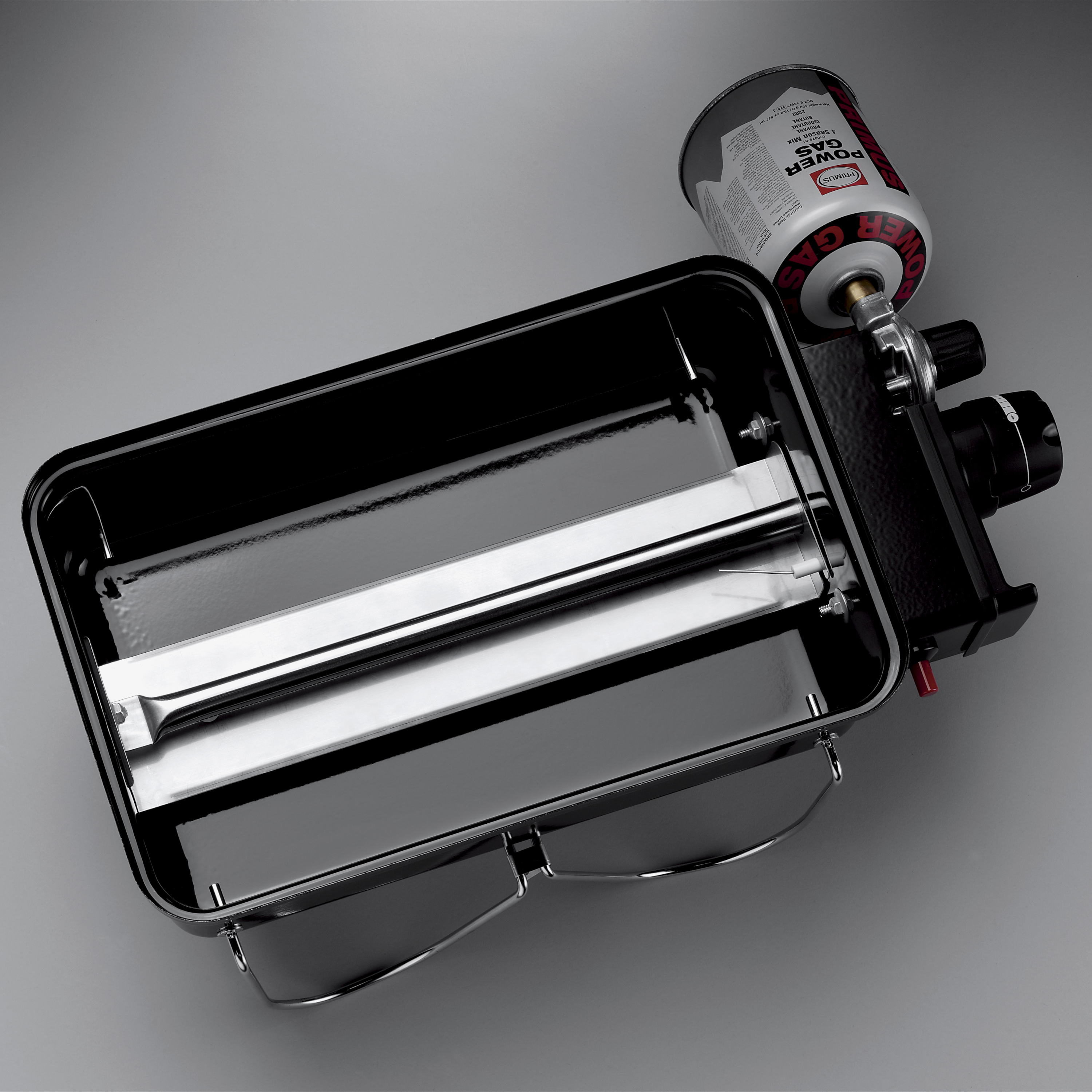 Przenośna kuchenka kempingowa z podłączonym kartuszem gazowym.