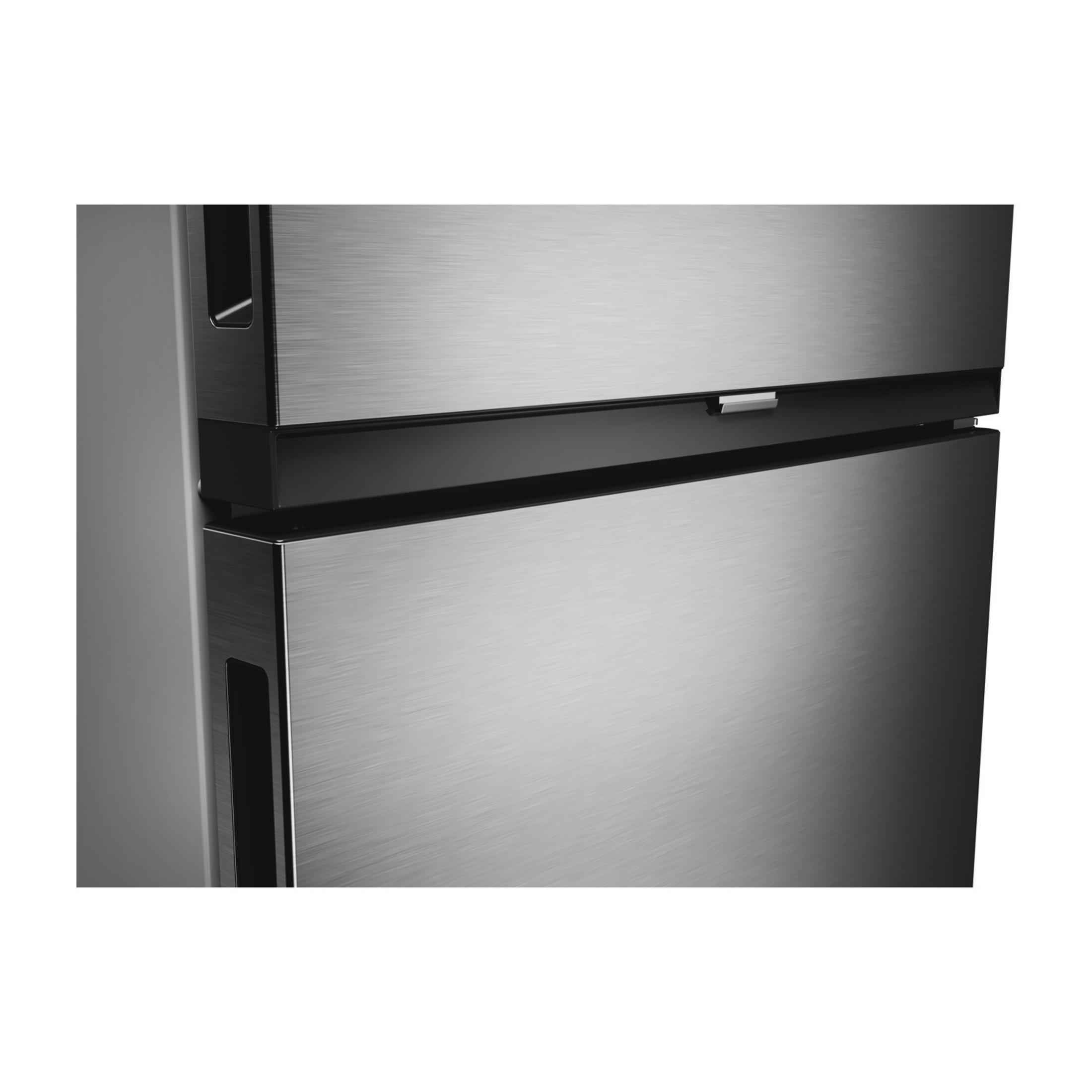 Puerta de refrigerador de acero inoxidable con área de mango oscura y rayas plateadas.