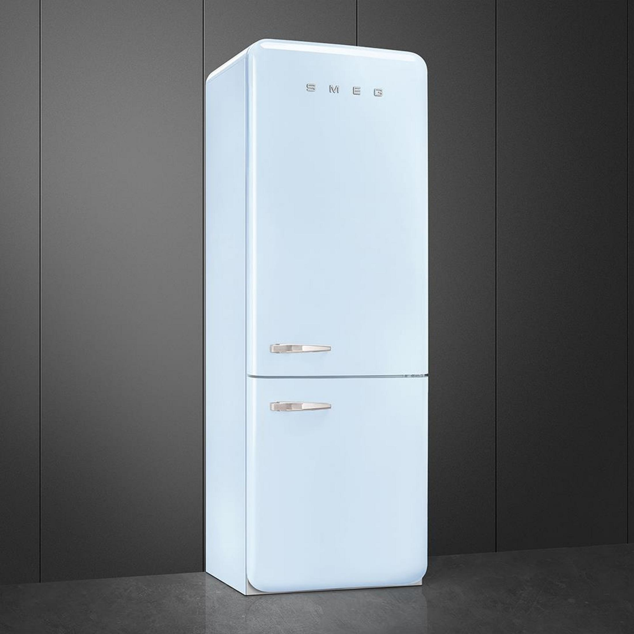 Un refrigerador SMEG azul claro con tiradores plateados sobre suelo oscuro.