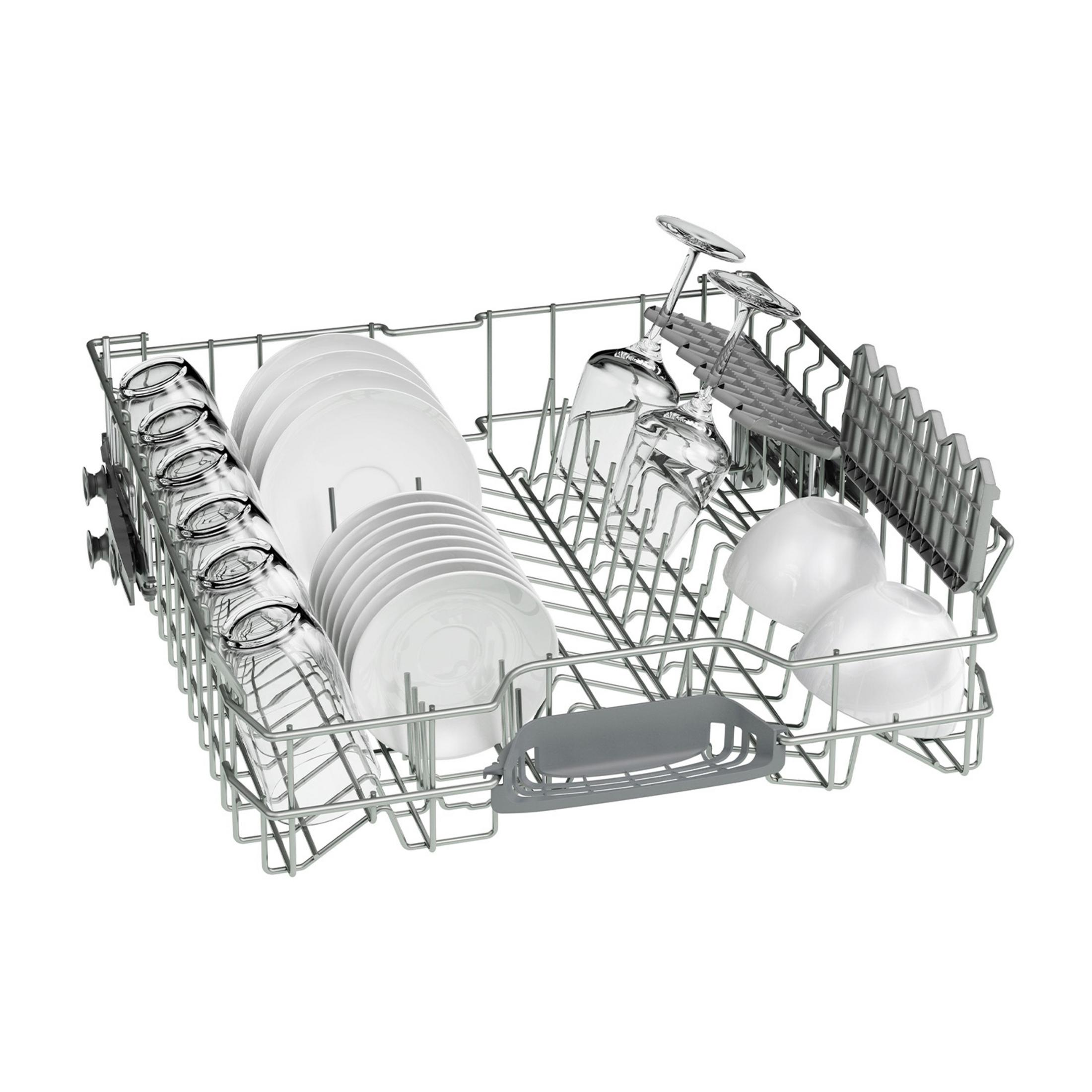 Kosz zmywarki z talerzami, szklankami i miskami. Białe talerze ułożone, szklanki pionowo, białe miski do góry nogami.