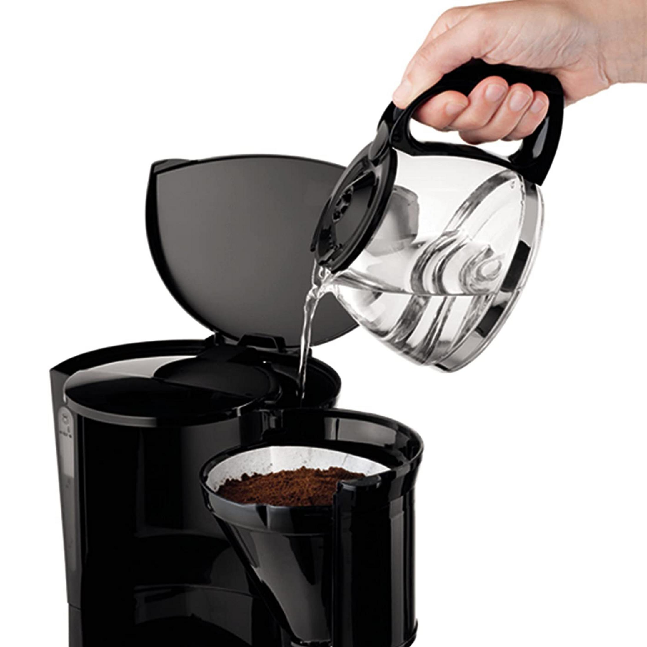 Woda jest wlewana do ekspresu do kawy z filtrem do kawy.