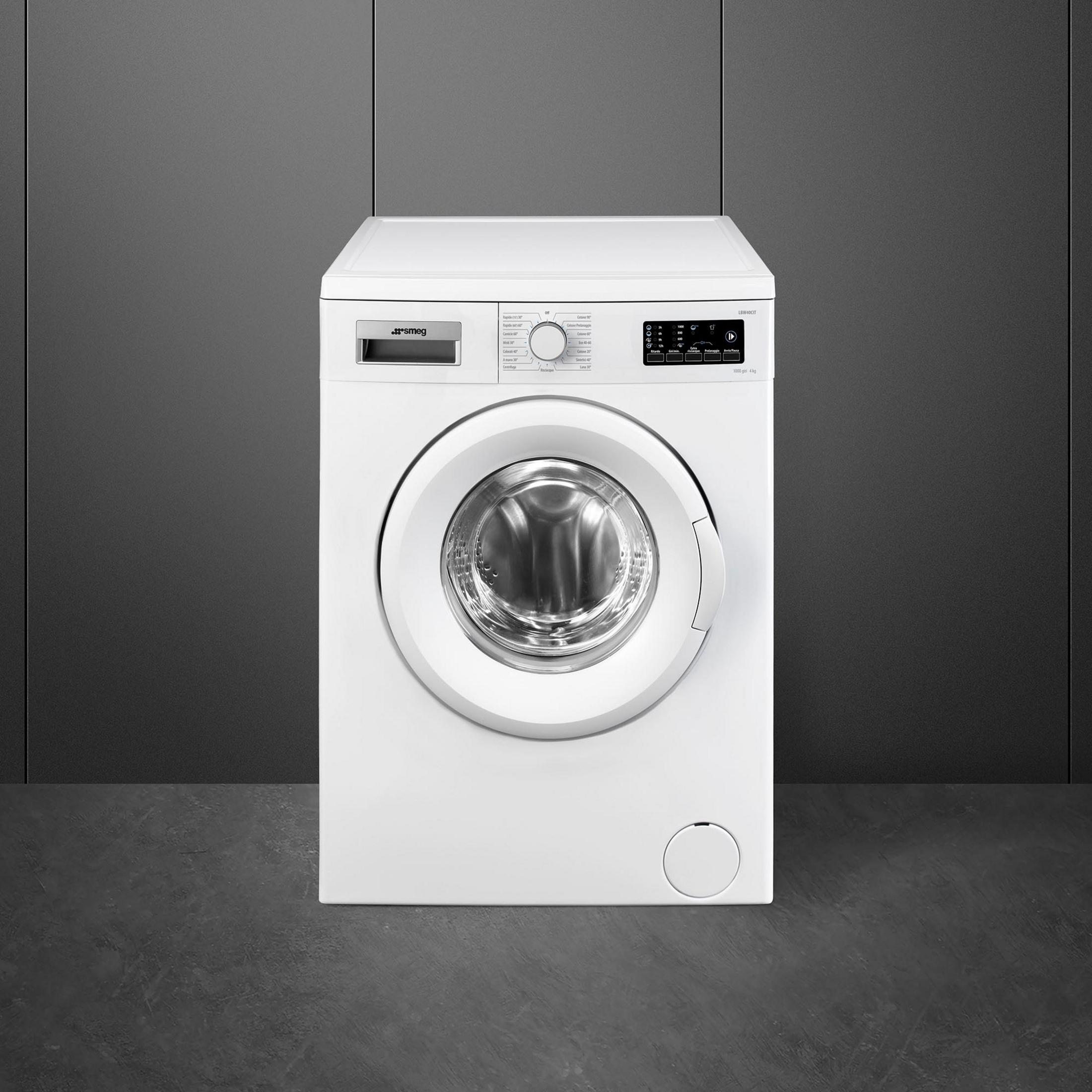 Biała pralka z okrągłymi drzwiami stoi na ciemnej podłodze.