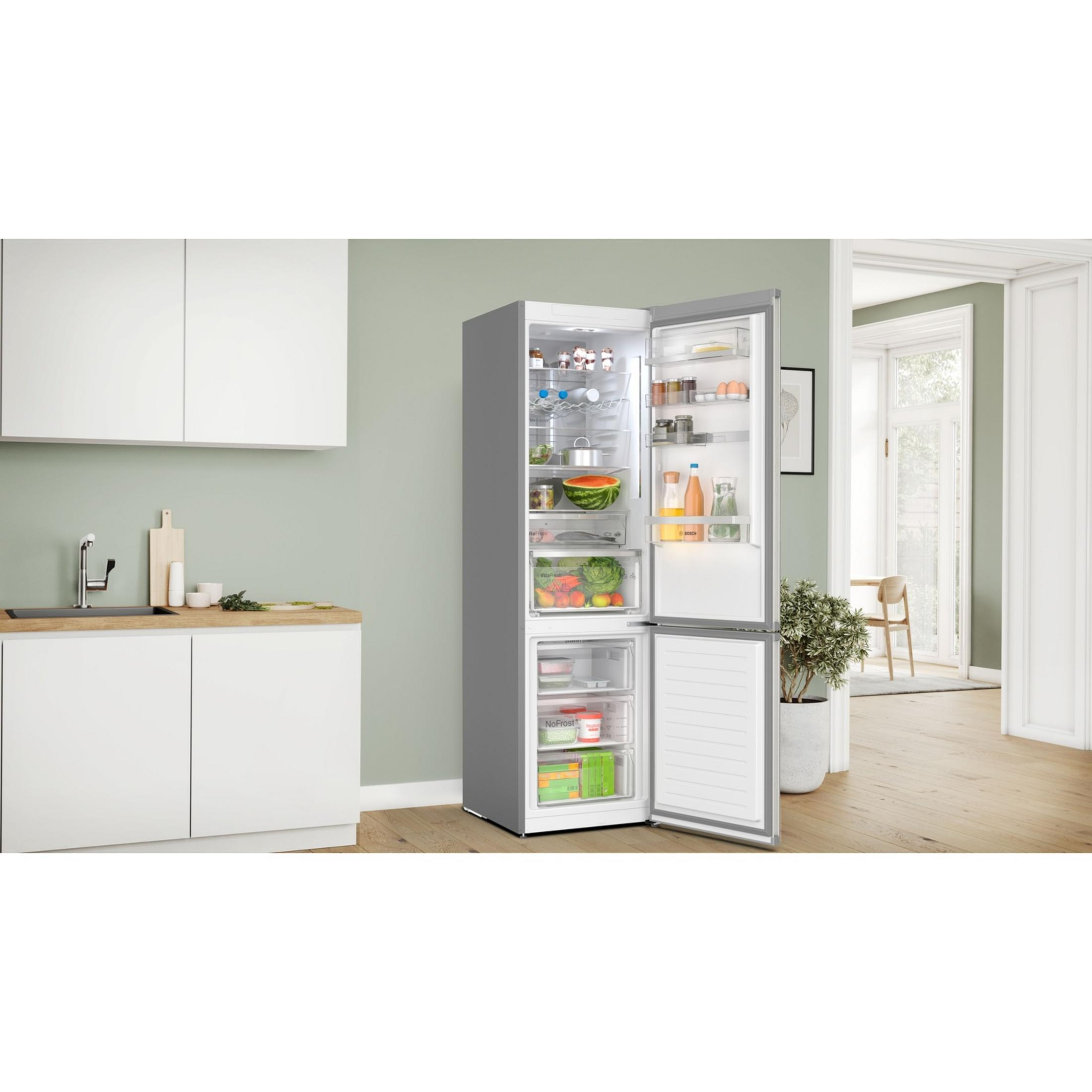 Un refrigerador abierto lleno de alimentos junto a una encimera de cocina.