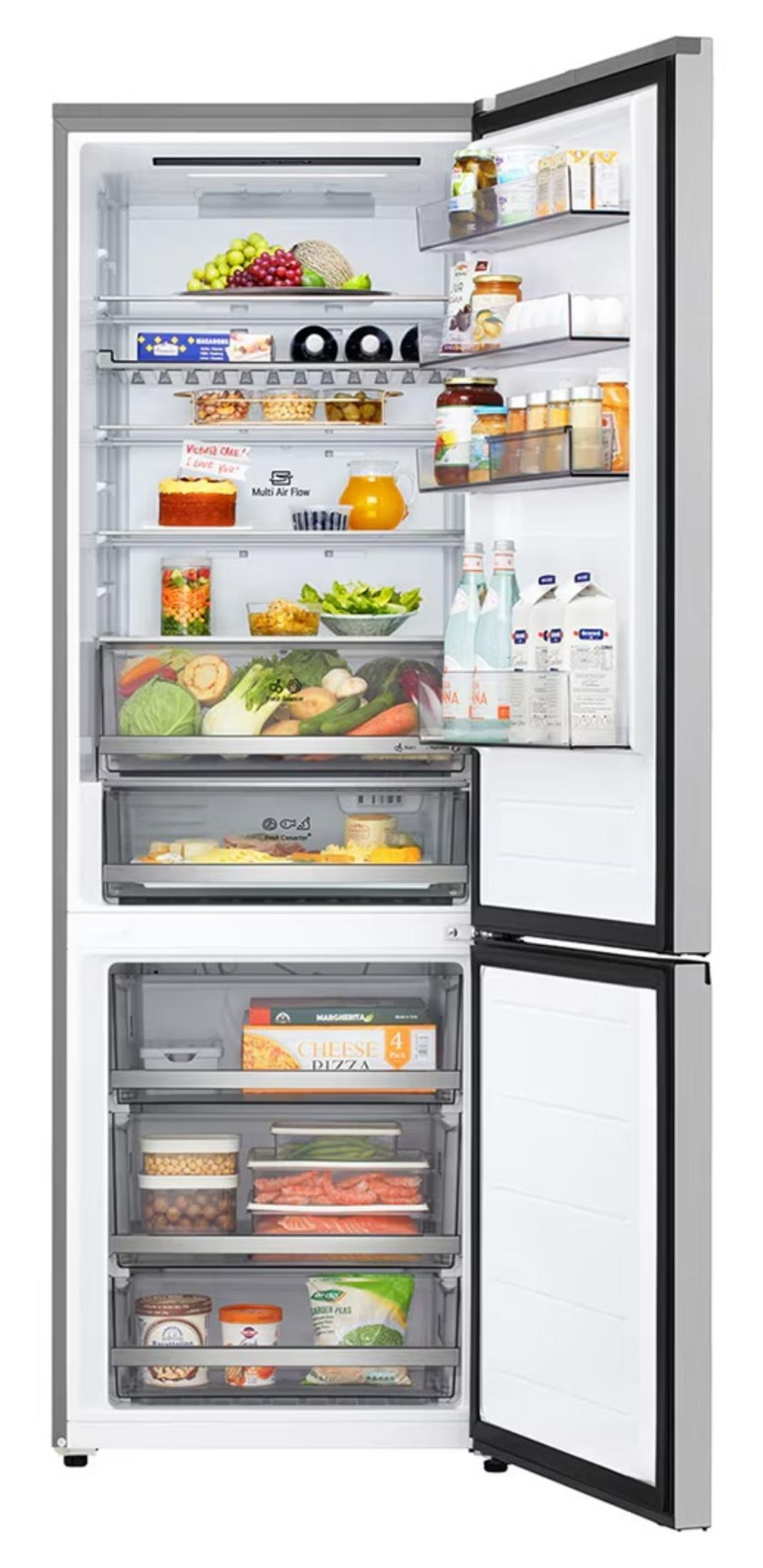 Refrigerador abierto con comida: frutas, verduras, bebidas, pizza y congelados.