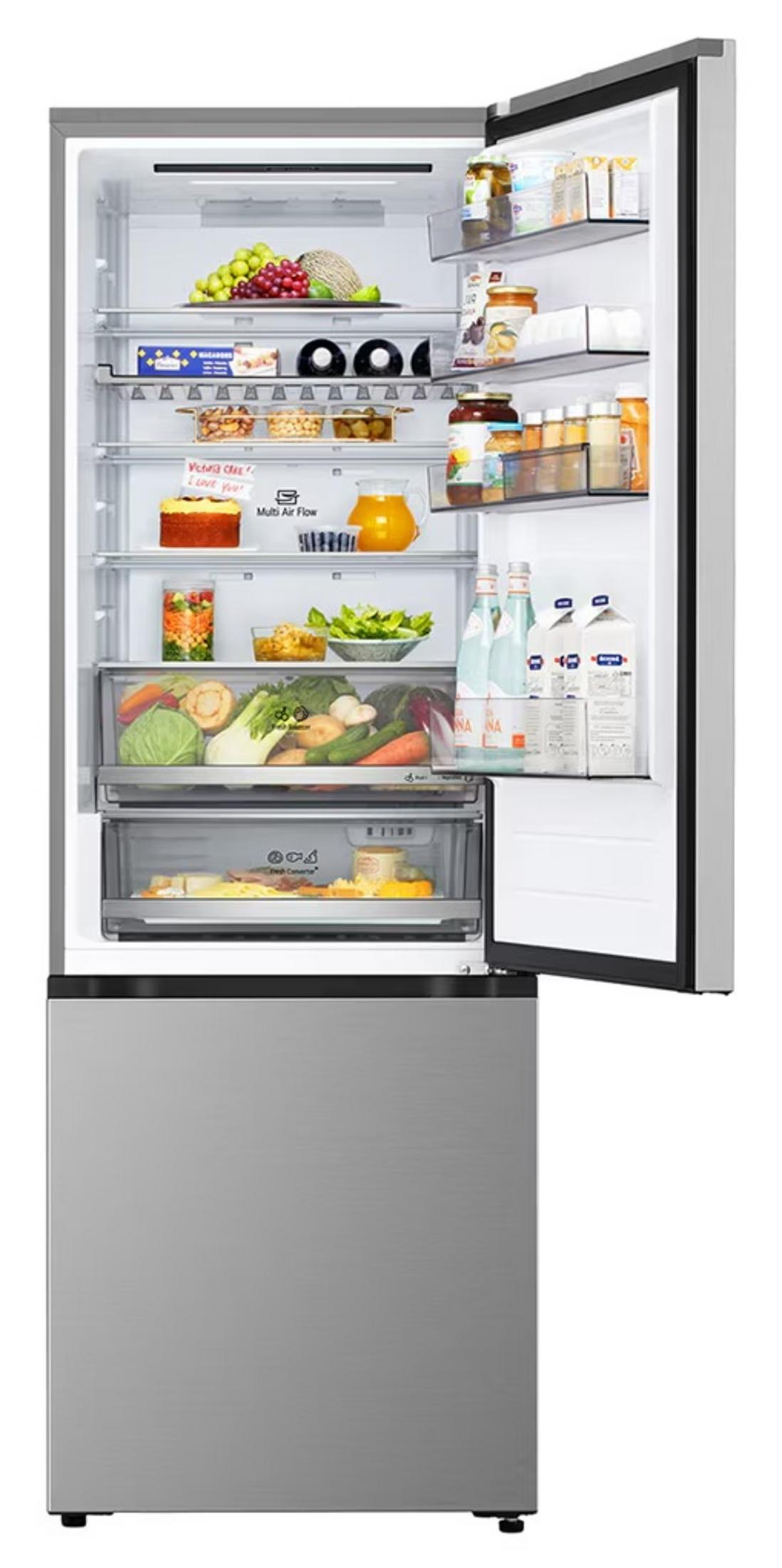 Refrigerador abierto lleno de frutas, comida, bebidas y cajones.