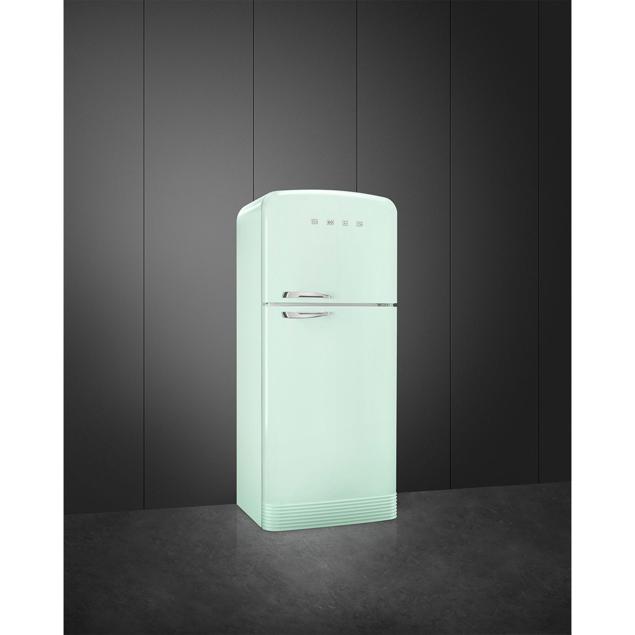 Un frigorífico Smeg verde claro de dos puertas sobre suelo oscuro.