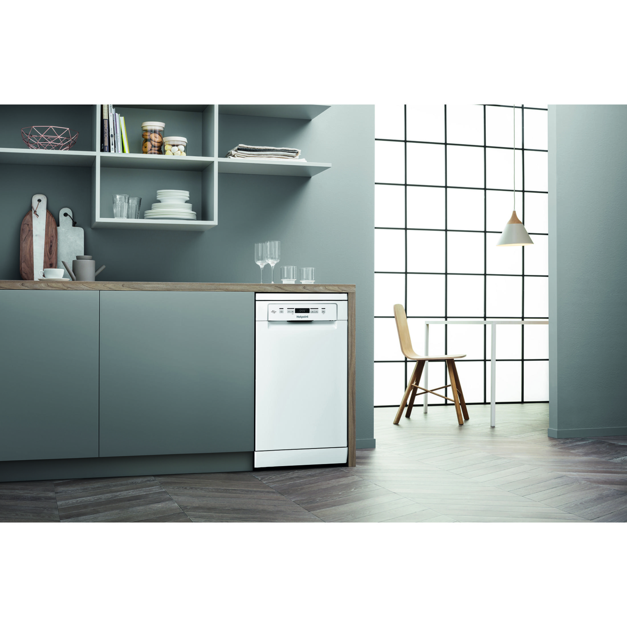 Lavastoviglie bianca in cucina moderna con mobili grigi e pavimento in legno.