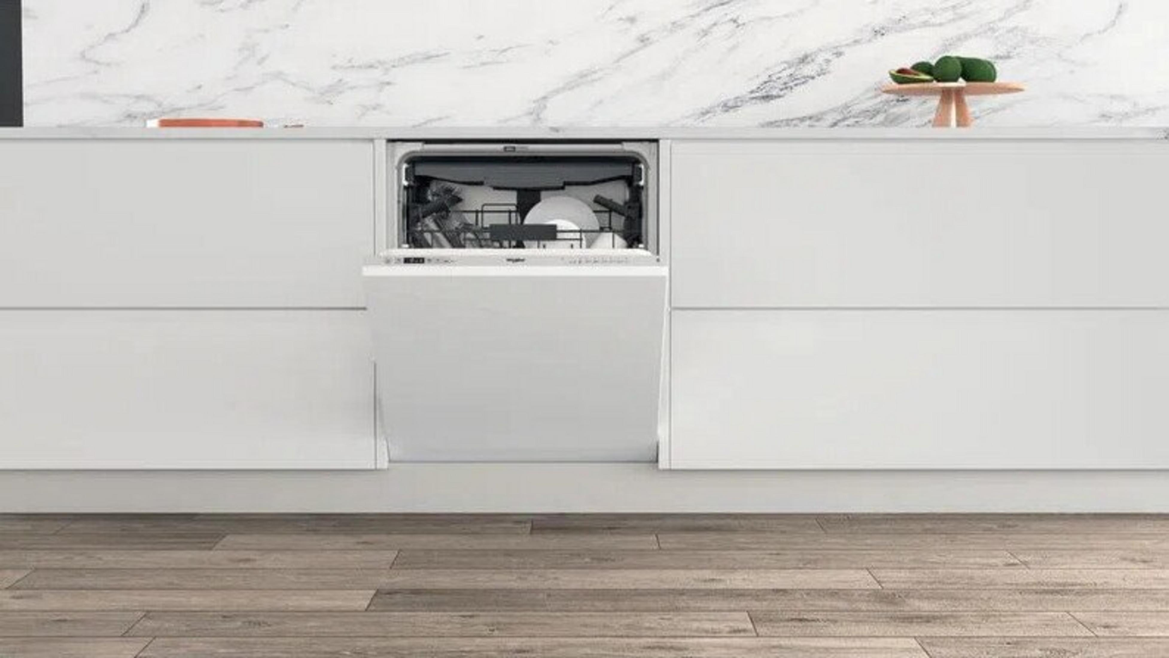 Una cucina bianca con lavastoviglie aperta e alzatina in marmo.