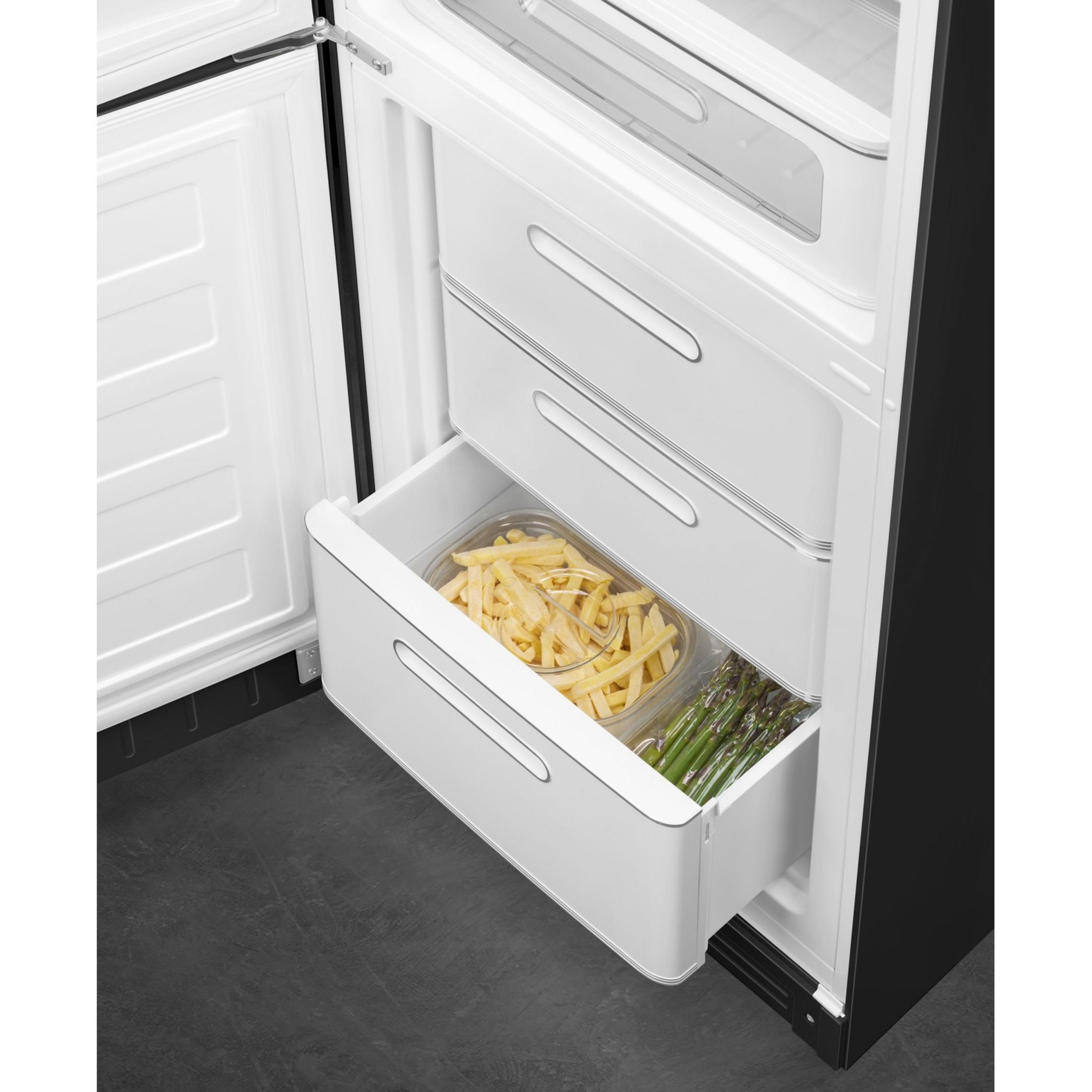 Gefrierfachschublade mit Pommes und grünem Spargel in Behältern.