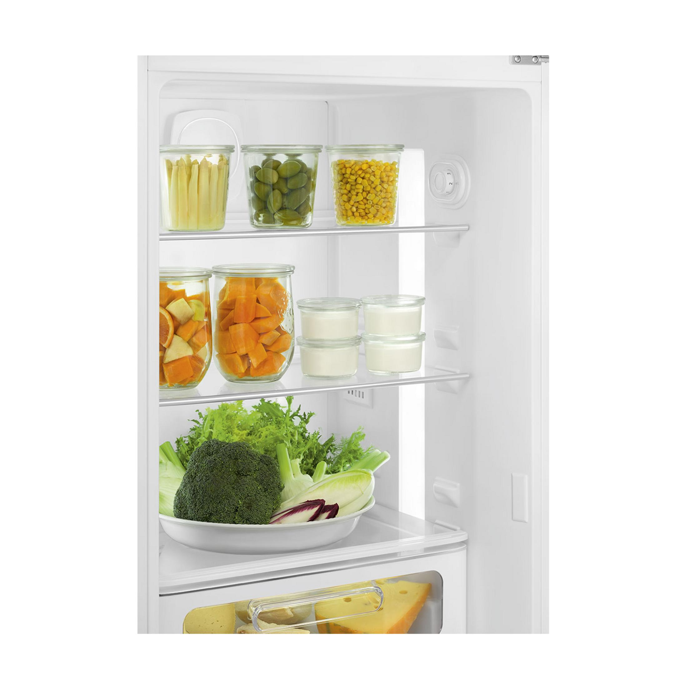 Un estante de refrigerador con frascos que contienen frijoles, maíz, naranjas y yogur.