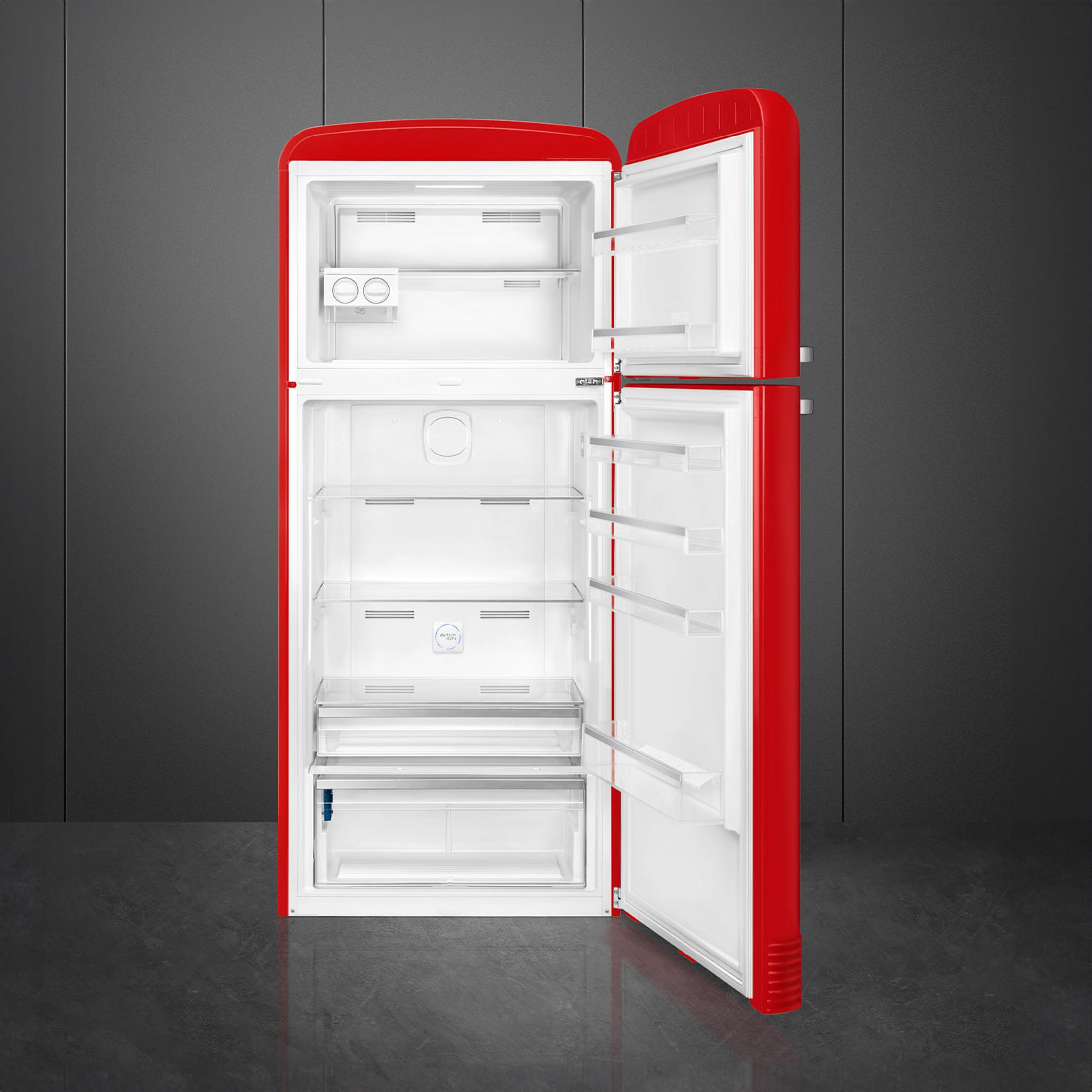 Un refrigerador rojo con las puertas abiertas, sobre suelo oscuro.