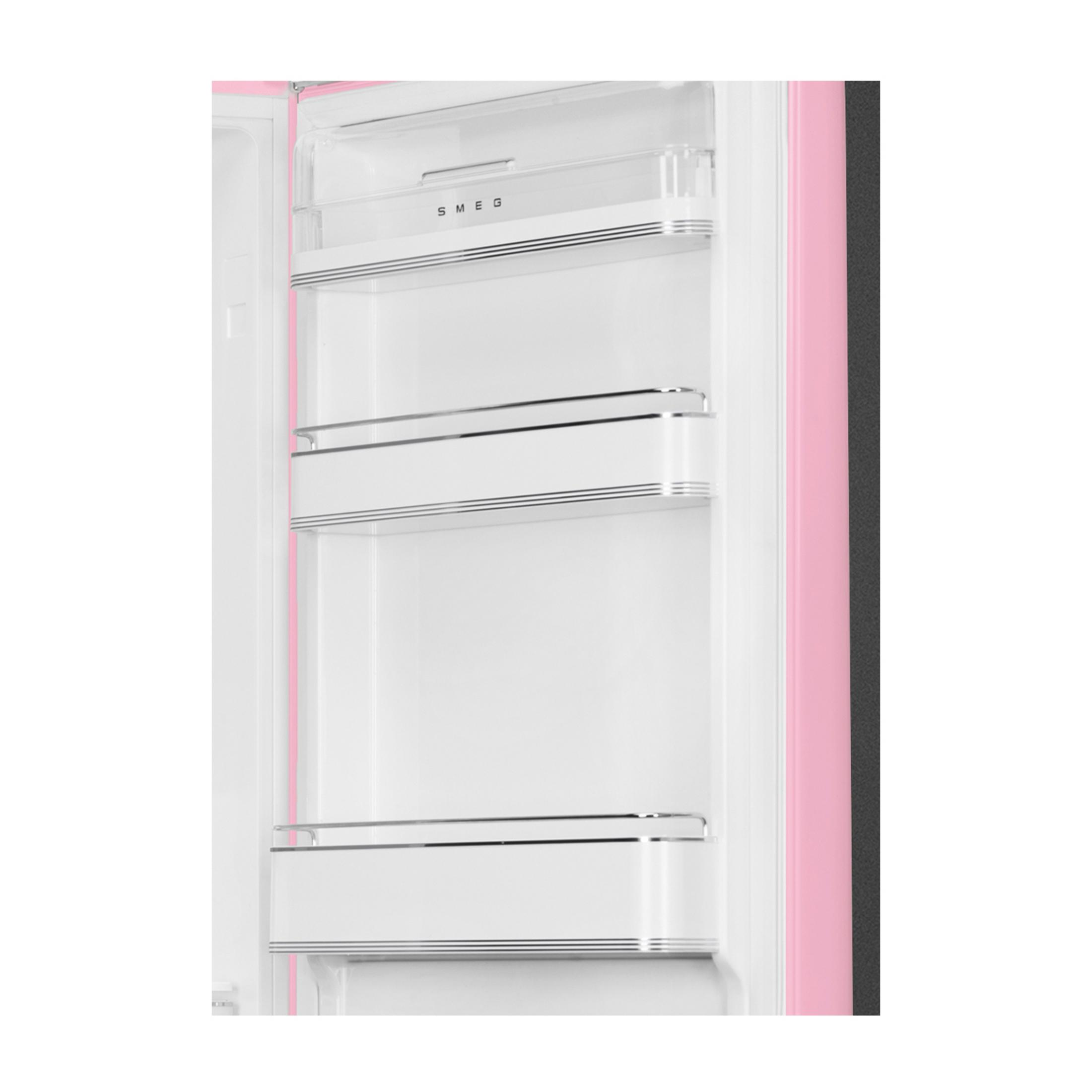 Vista interior de un frigorífico SMEG rosa con estantes blancos y detalles cromados.