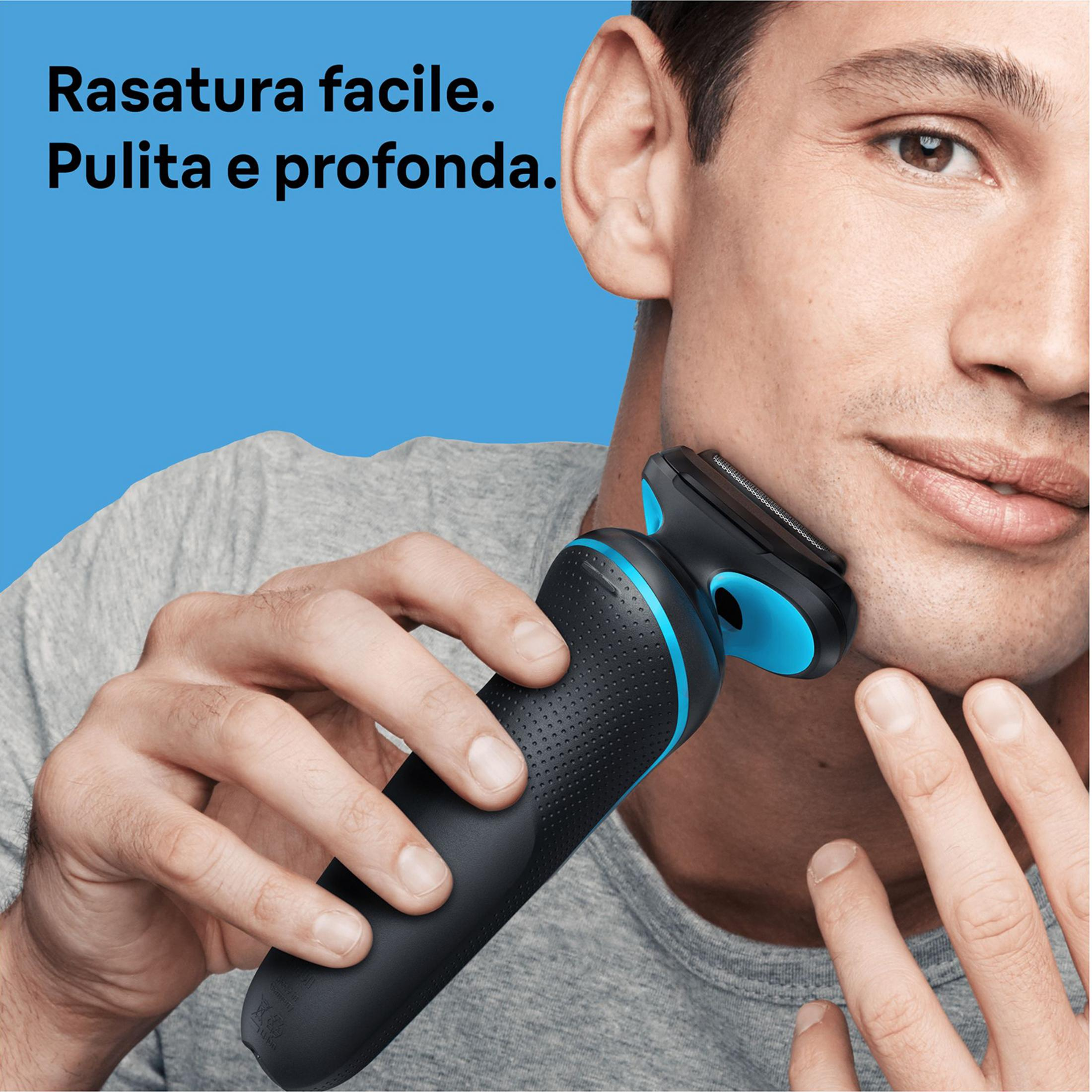 Mężczyzna goli twarz czarno-niebieską golarką elektryczną.