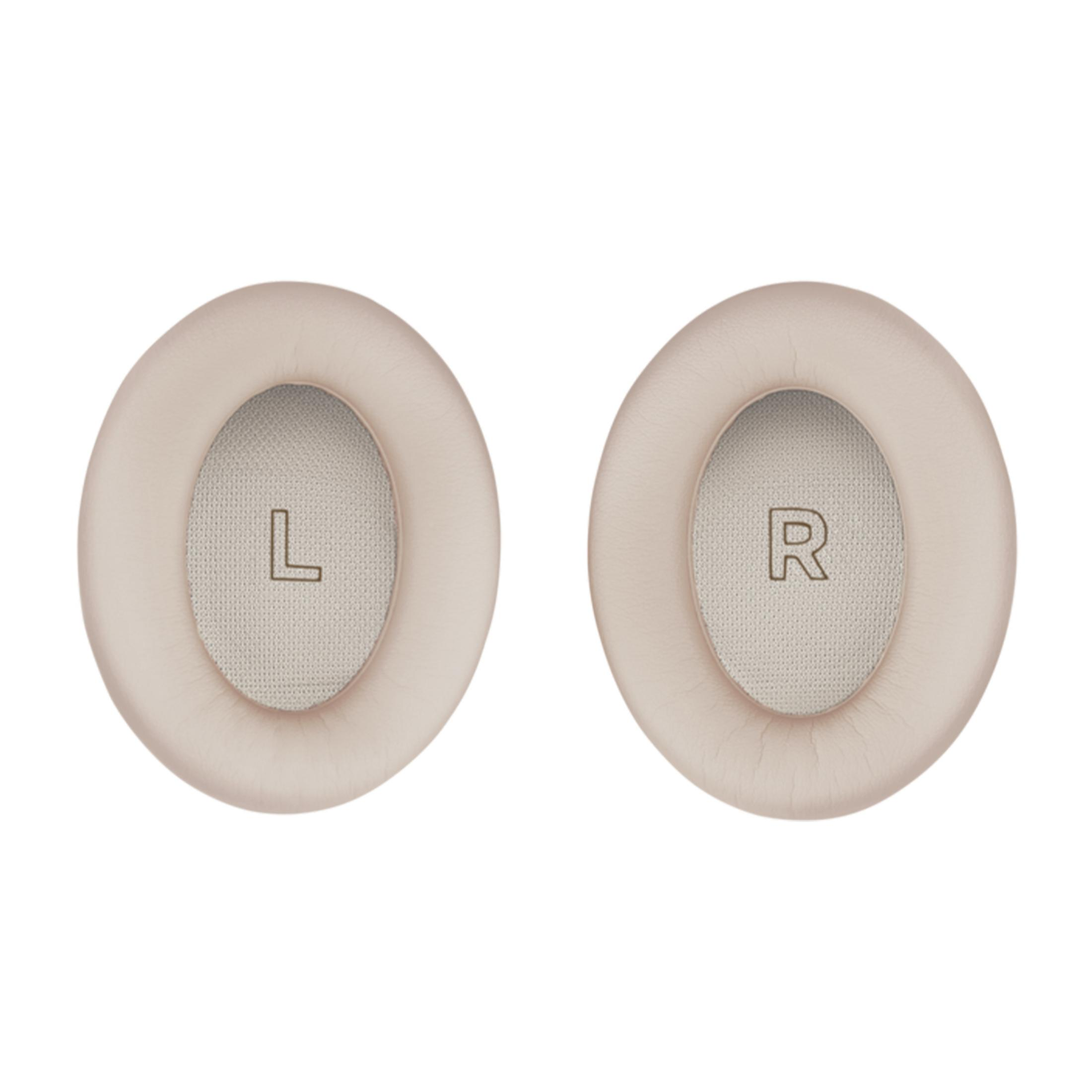 Zwei beige Ohrpolster, links mit 'L', rechts mit 'R'.
