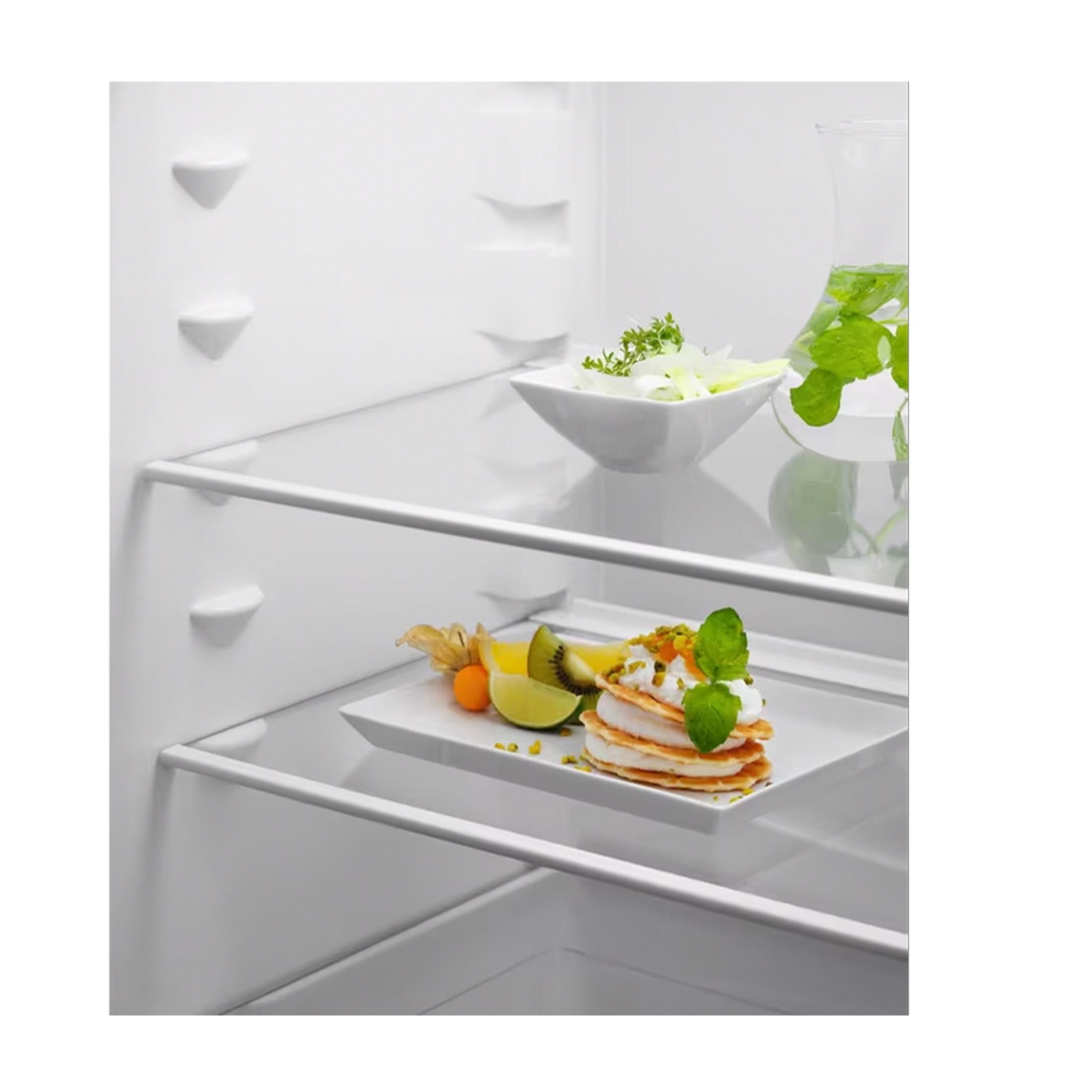 Naleśniki z owocami i sałatką w karafce w lodówce.