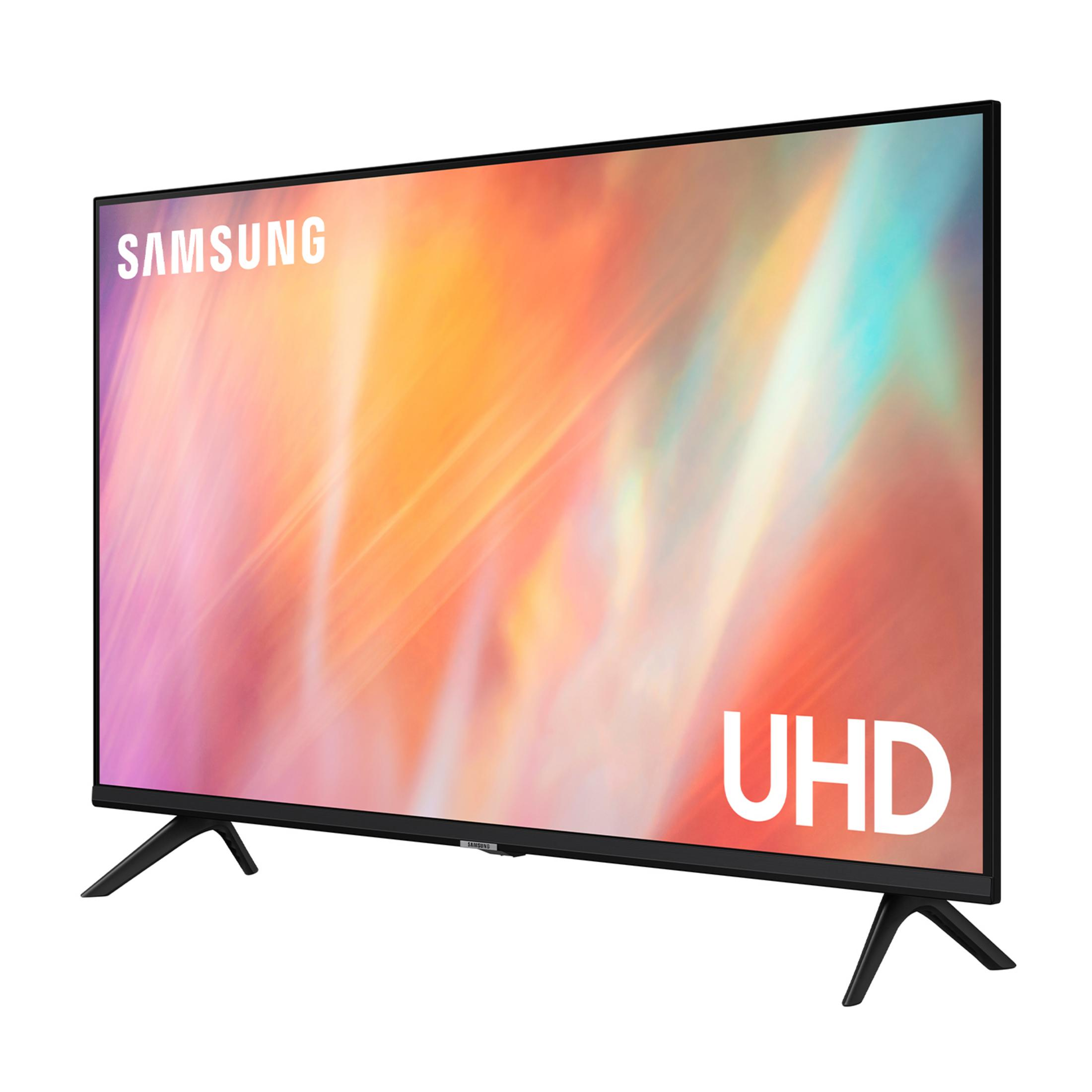 Telewizor Samsung UHD z kolorowym tłem stoi na dwóch czarnych stopkach.
