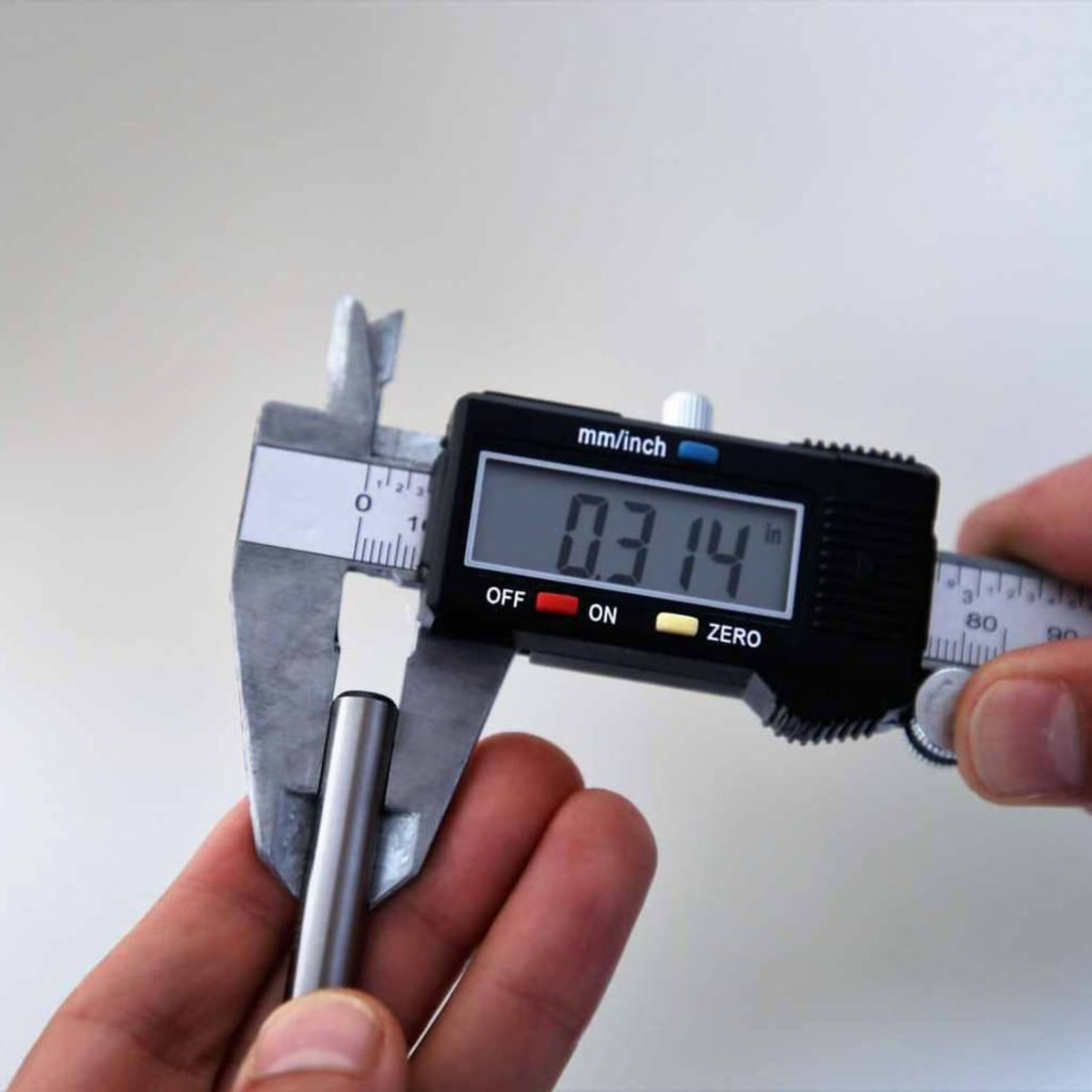 Messung eines Zylinders mit einem digitalen Messschieber, der 0,314 Zoll anzeigt.