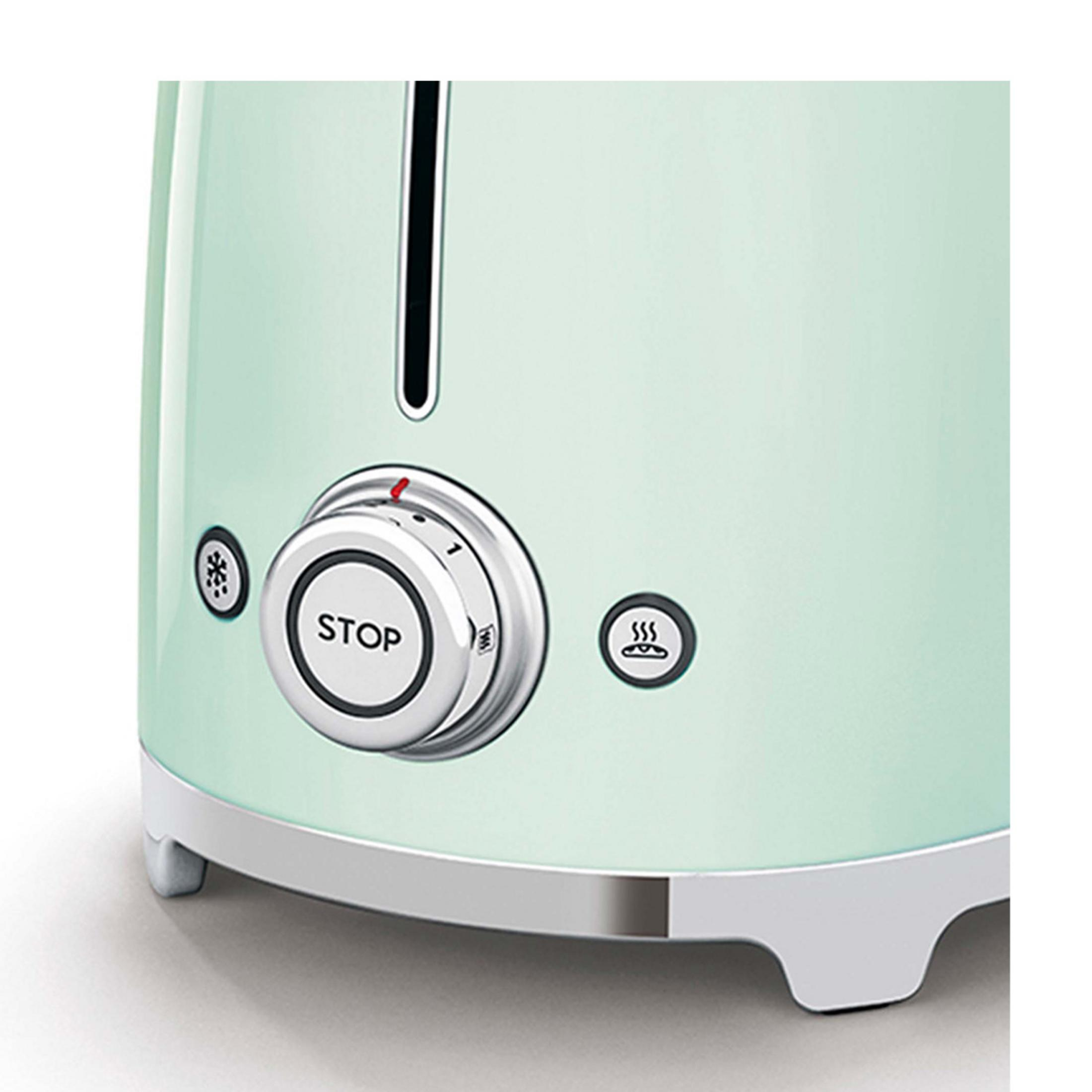 Zbliżenie miętowej zielonej tostera z srebrnym pokrętłem i ikonami.