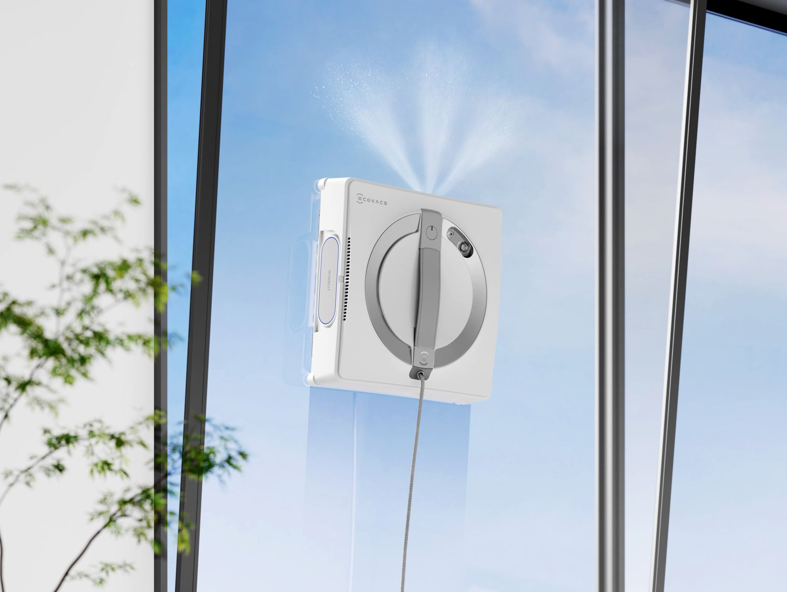 Biały robot do mycia okien rozpyla wodę na okno.