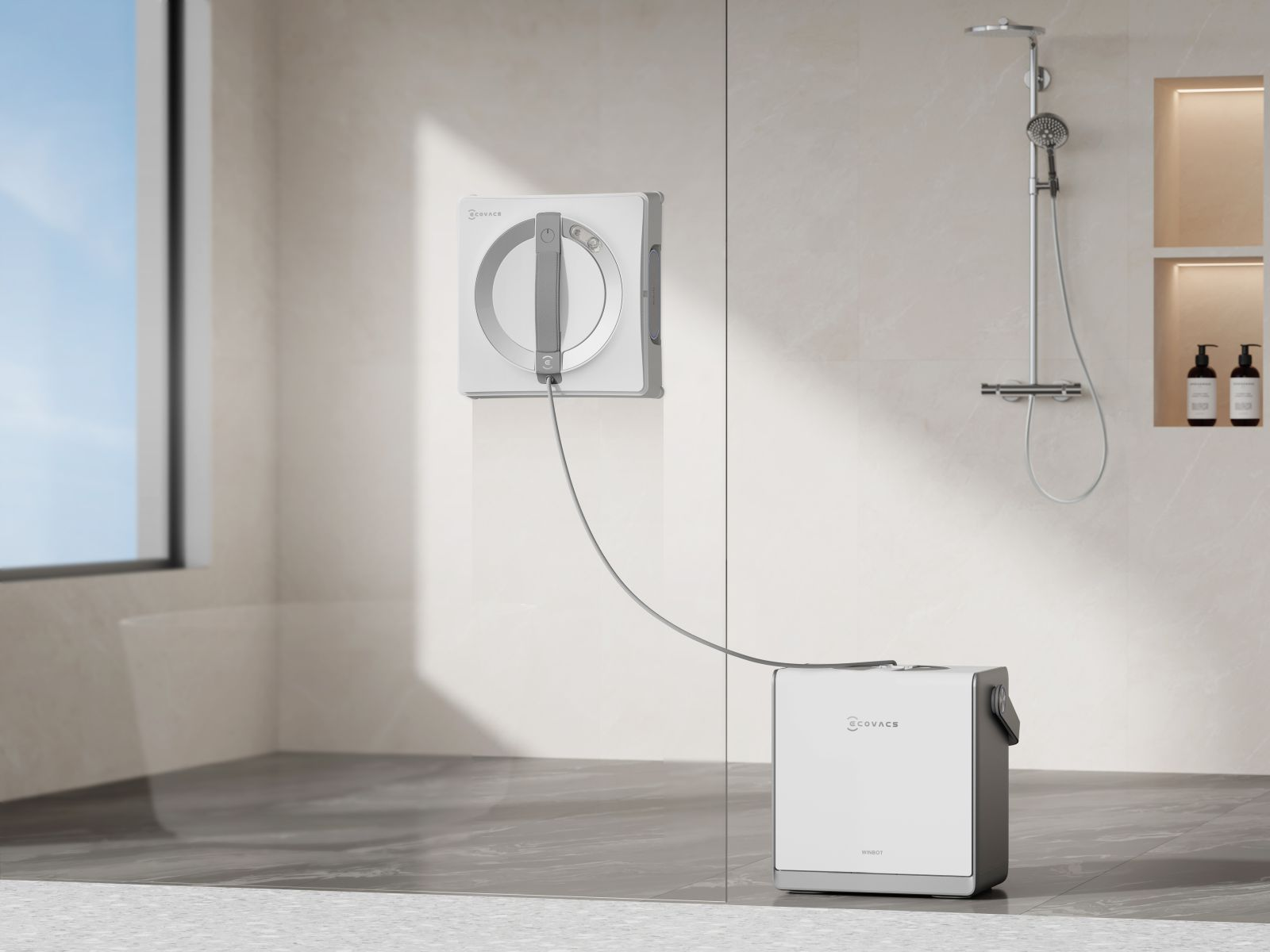 Biały robot do czyszczenia okien przylega do szklanej ściany obok prysznica.