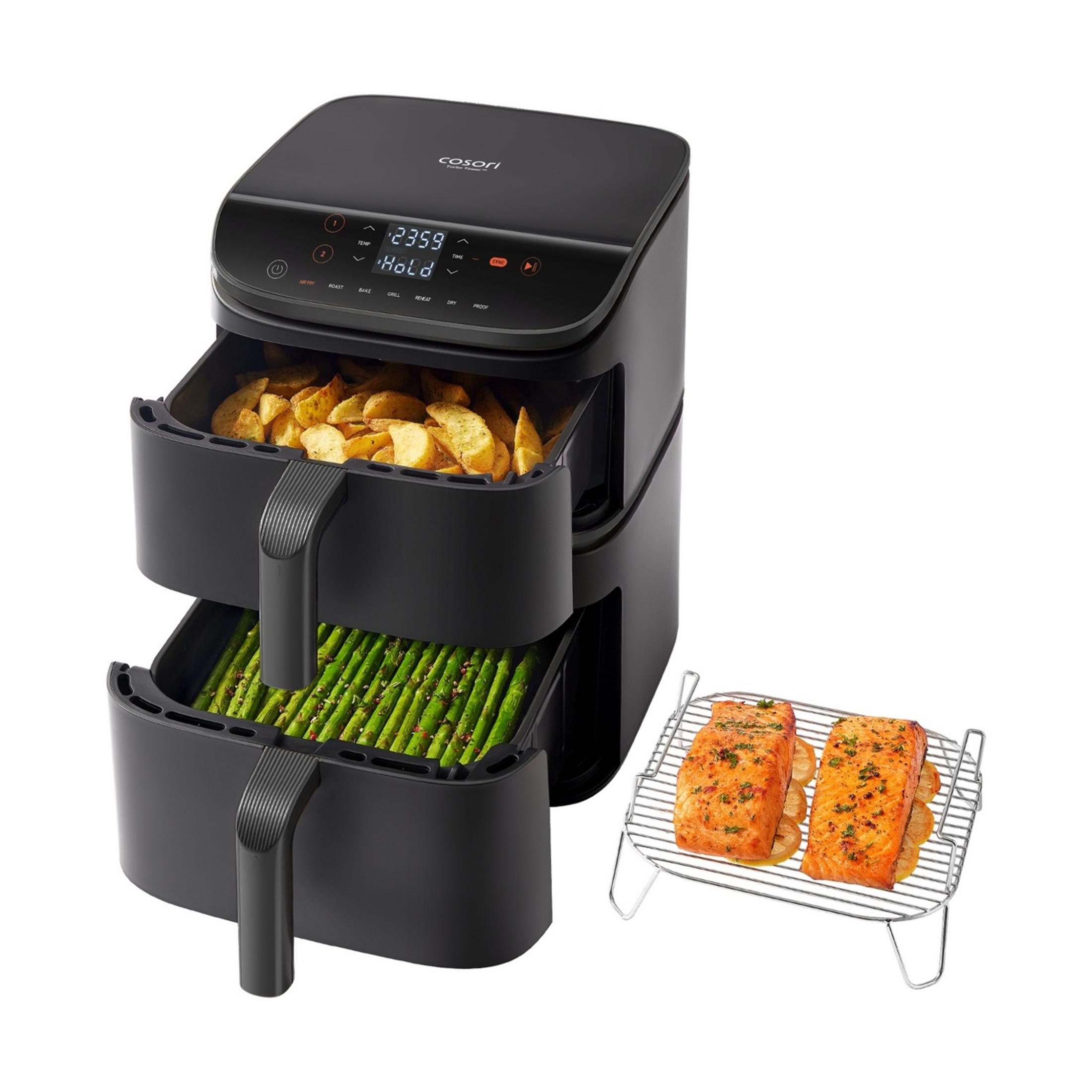 Czarna frytkownica beztłuszczowa z dwoma koszami, frytkami i szparagami, obok łososia na ruszcie.