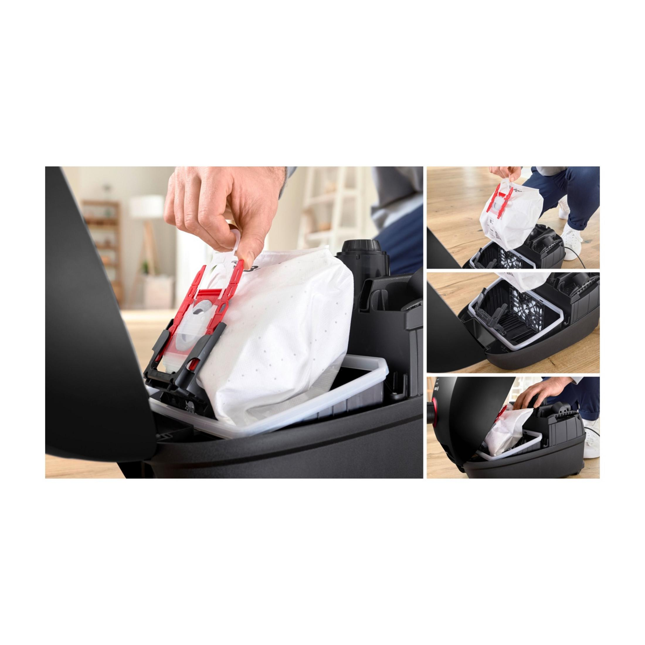 Mężczyzna wymienia worek w odkurzaczu. Widok z bliska.