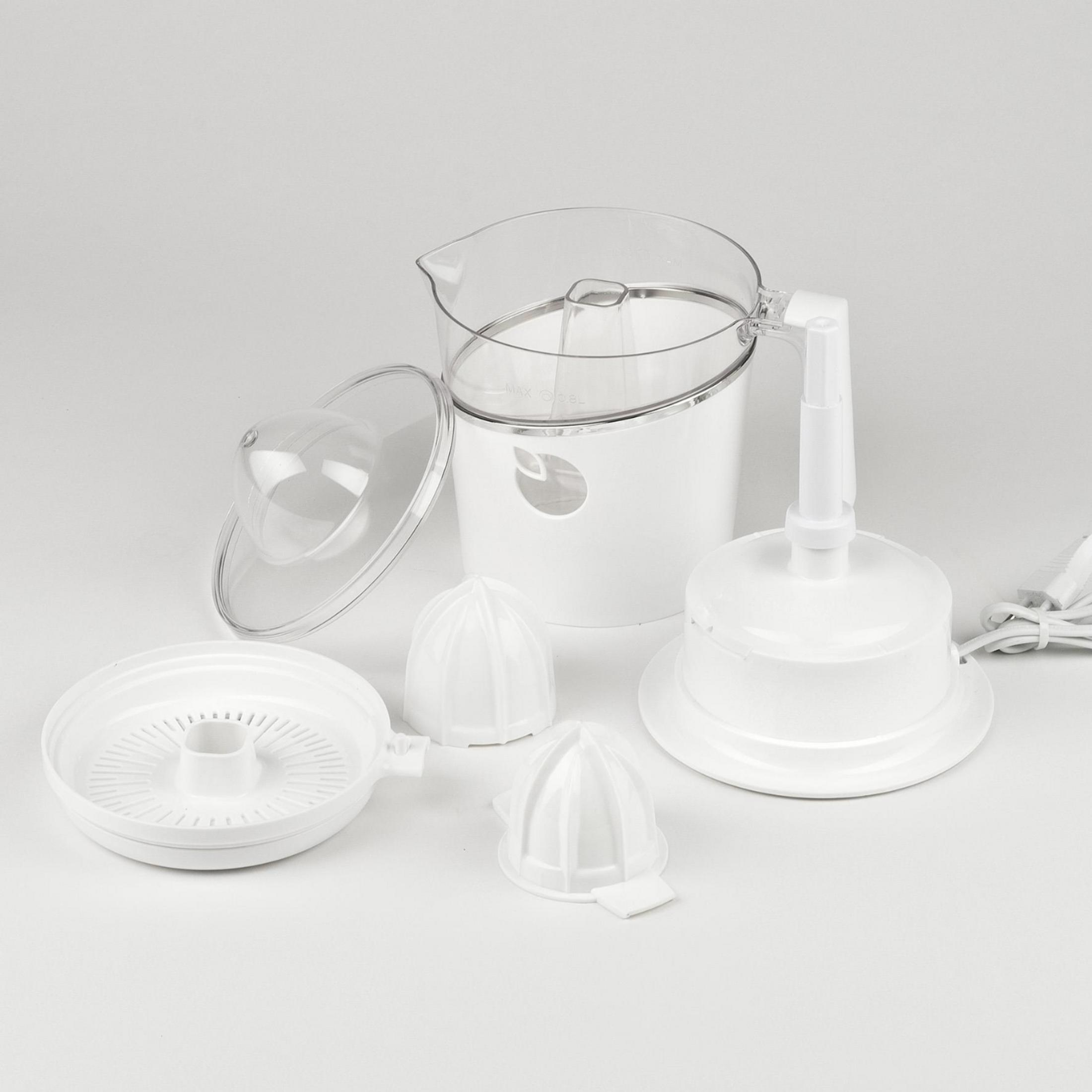 Un spremiagrumi elettrico bianco con accessori, inclusi spremiagrumi e caraffa.