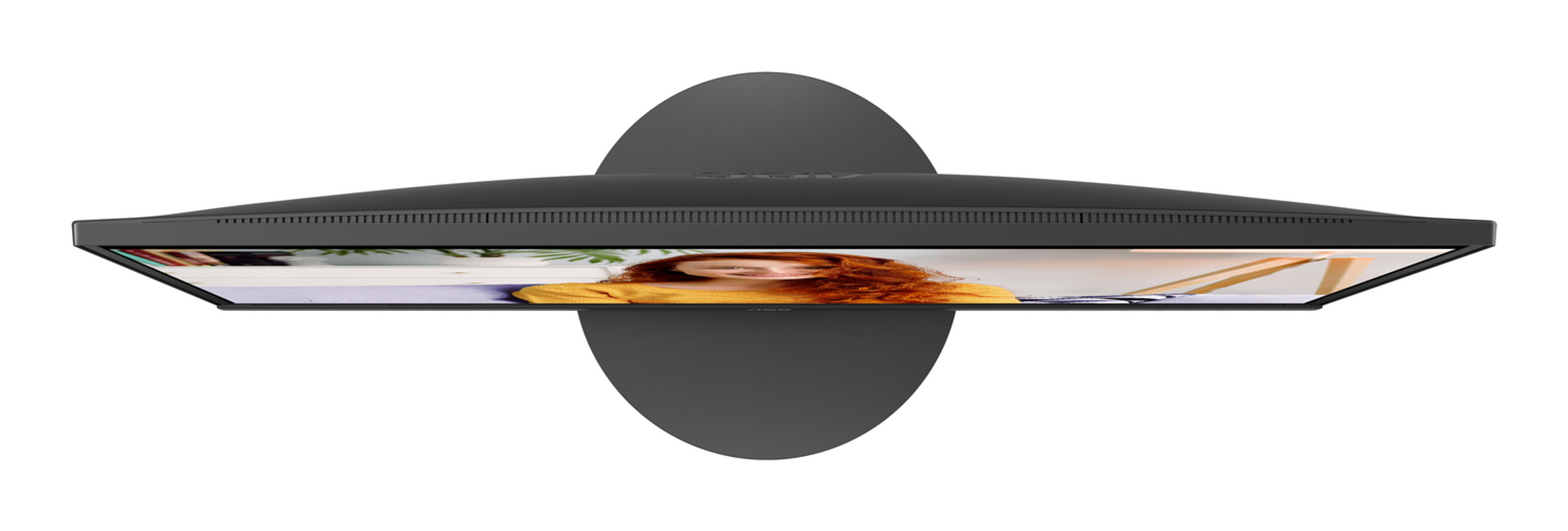 Kobieta z rudymi włosami siedzi przed monitorem wyświetlającym rośliny i drewnianą ramę.