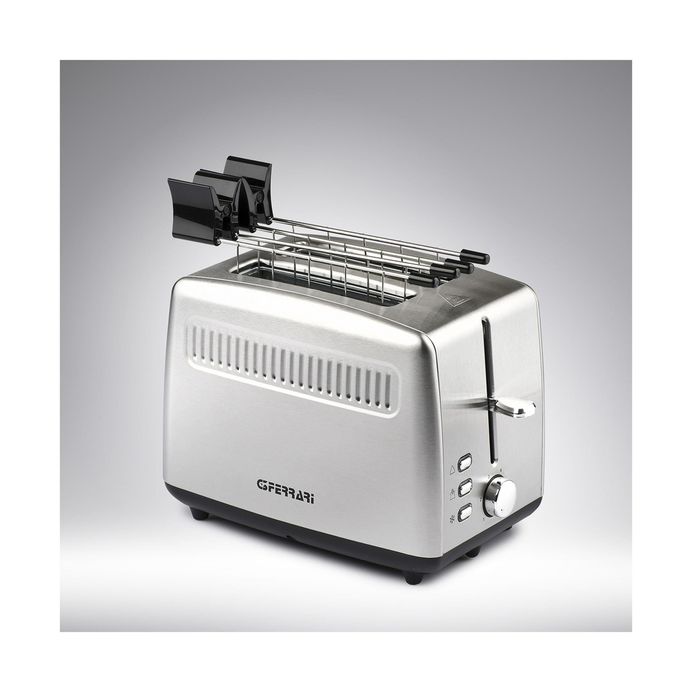 Srebrny toster z czarnymi uchwytami i pokrętłami na szarym tle.