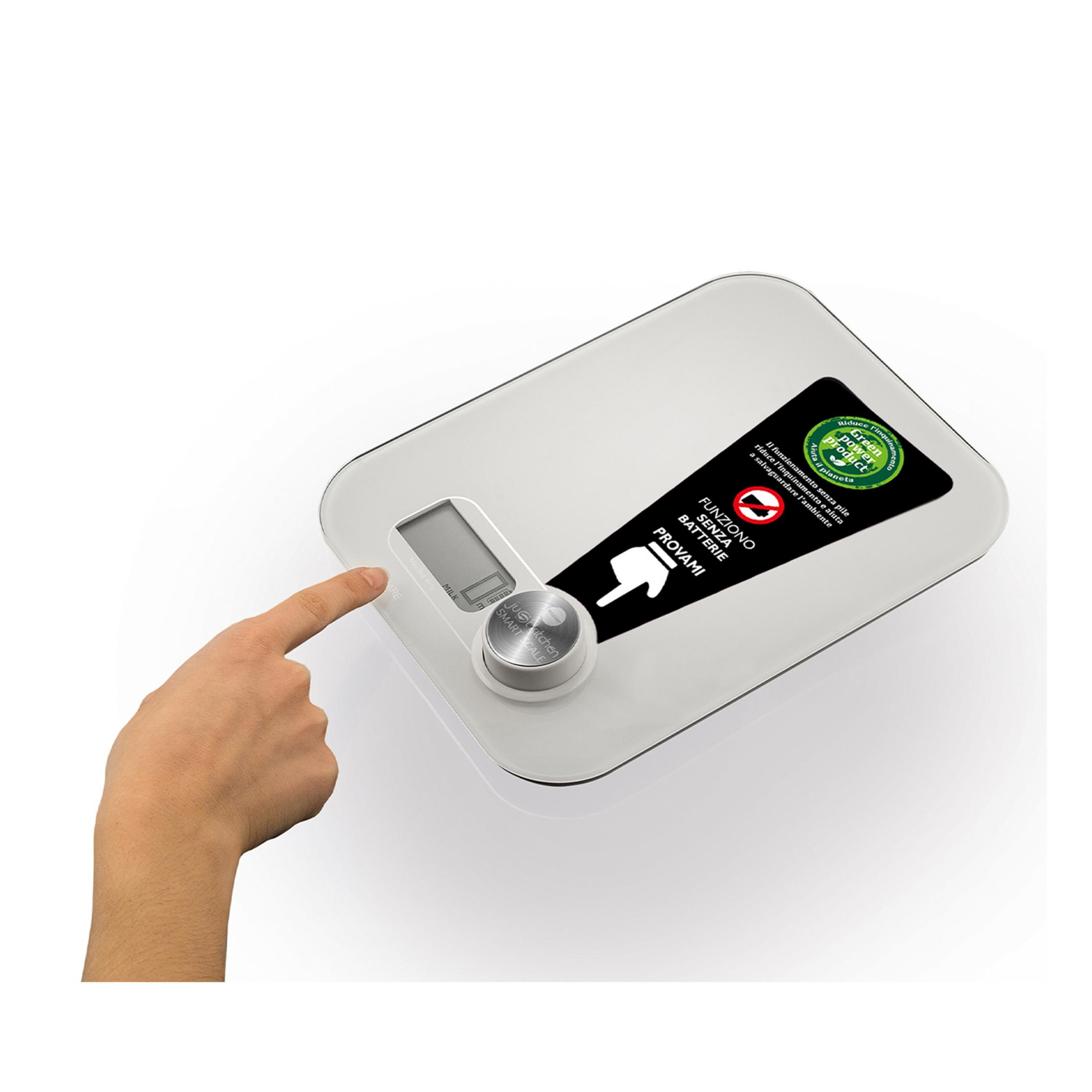 Dłoń naciska na białą cyfrową wagę kuchenną działającą bez baterii.