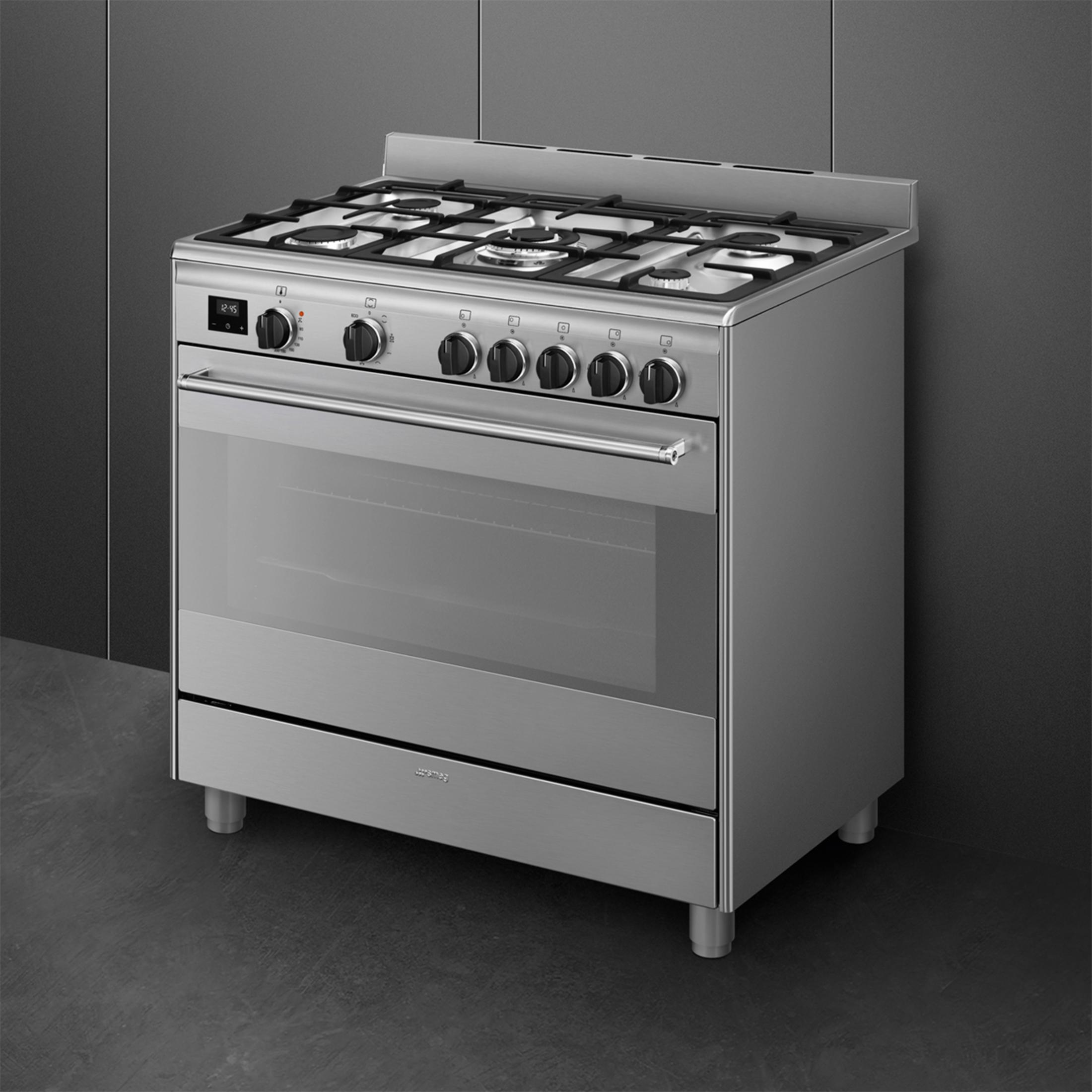 Fornello a gas moderno argentato con quattro fuochi e porta del forno.
