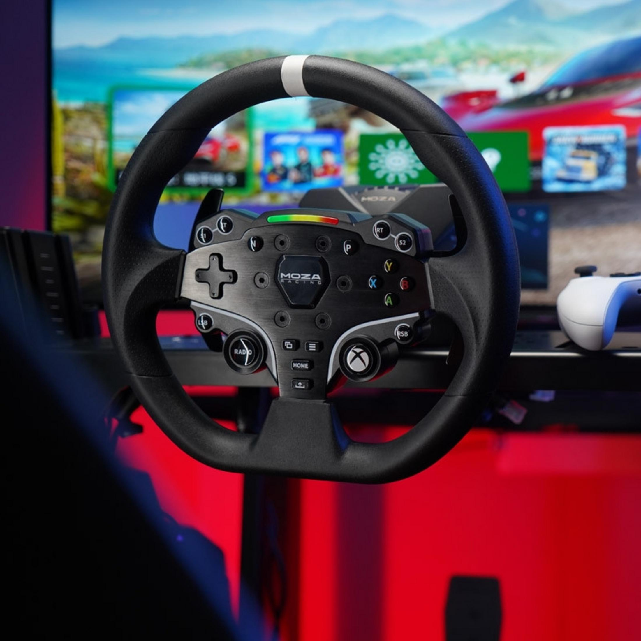 Un volant de course noir avec un centre en métal et des lumières colorées devant un écran de jeu.