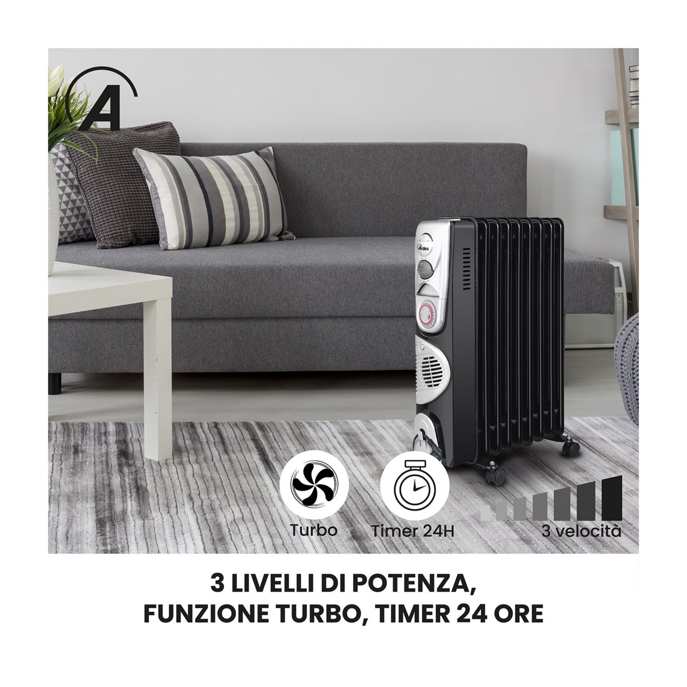 Una stufa a olio nera accanto a un divano grigio, con cuscini e tappeto.