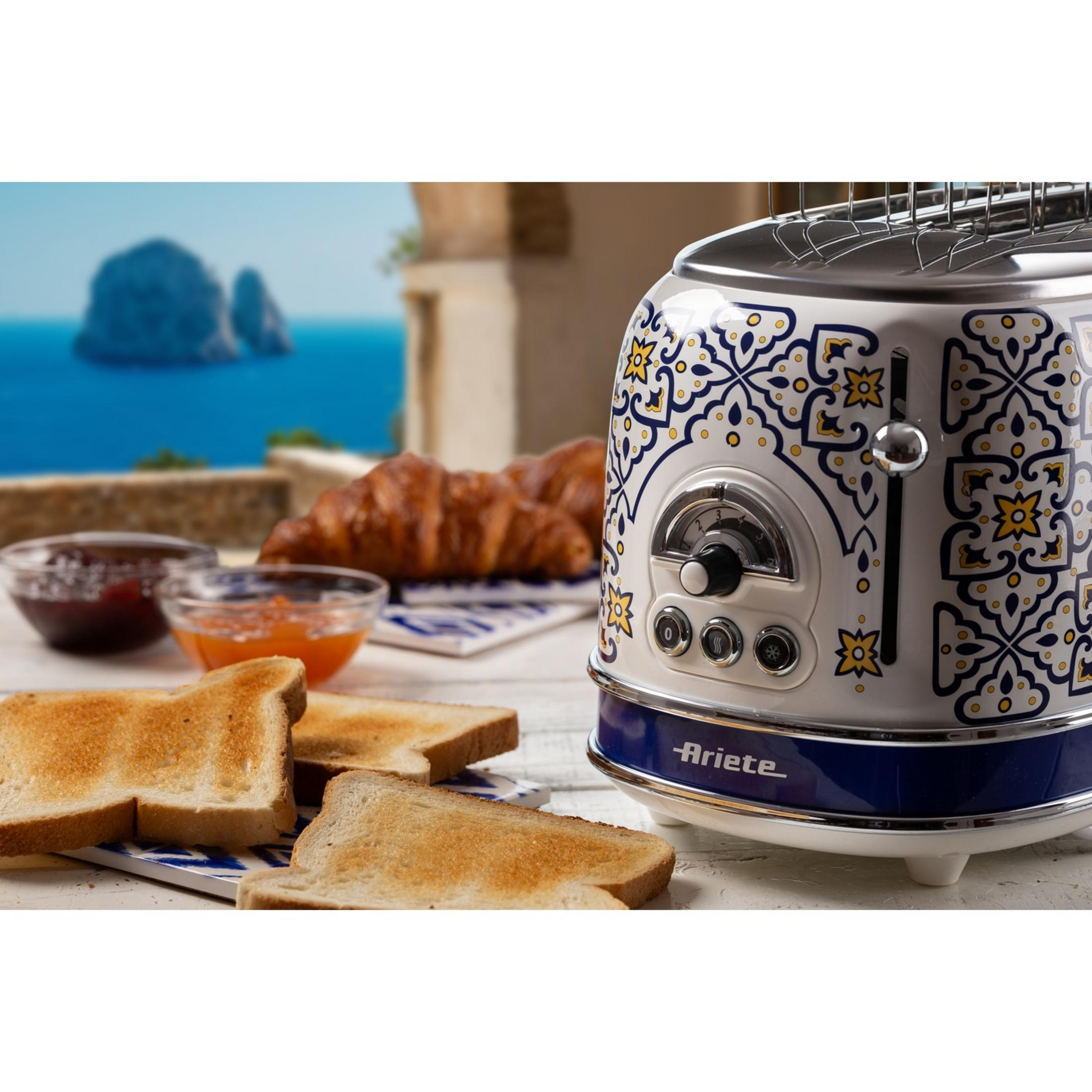 Dekoracyjny toster z tostami, croissantami i dżemem nad morzem.