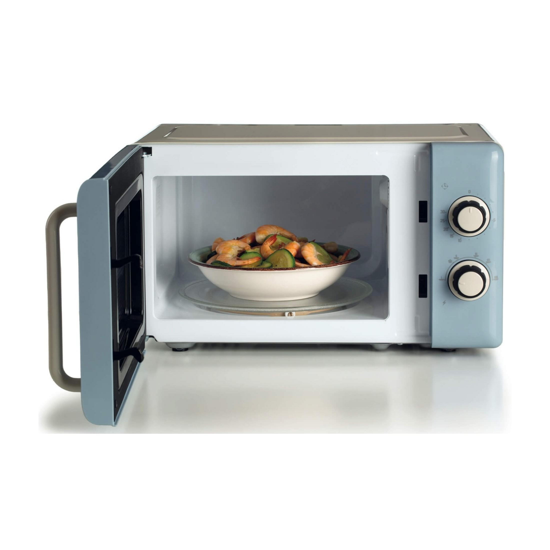Niebieska kuchenka mikrofalowa z otwartymi drzwiami, zawierająca miskę krewetek i cukinii.