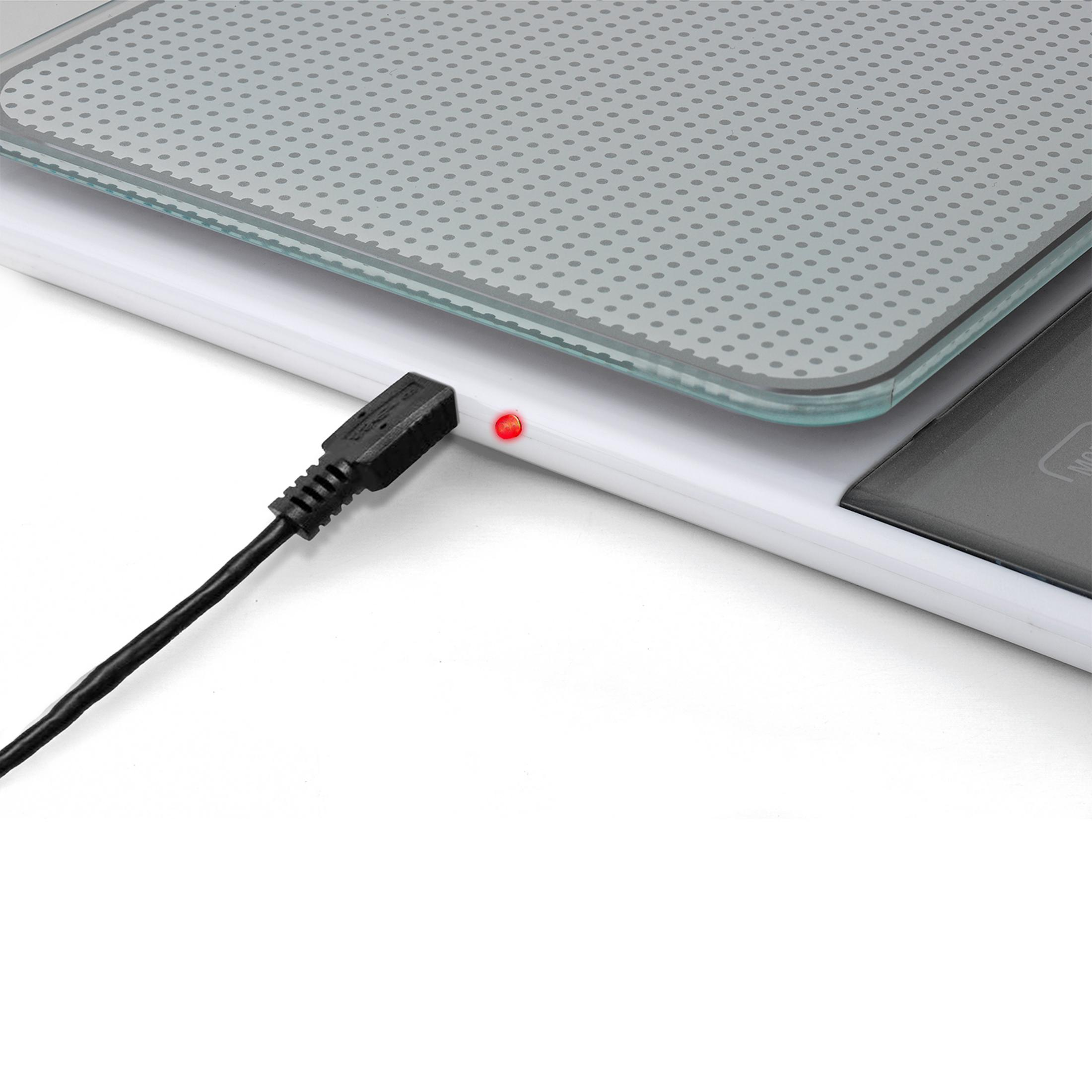 Zbliżenie wagi cyfrowej z podłączonym kablem USB i czerwoną diodą ładowania.