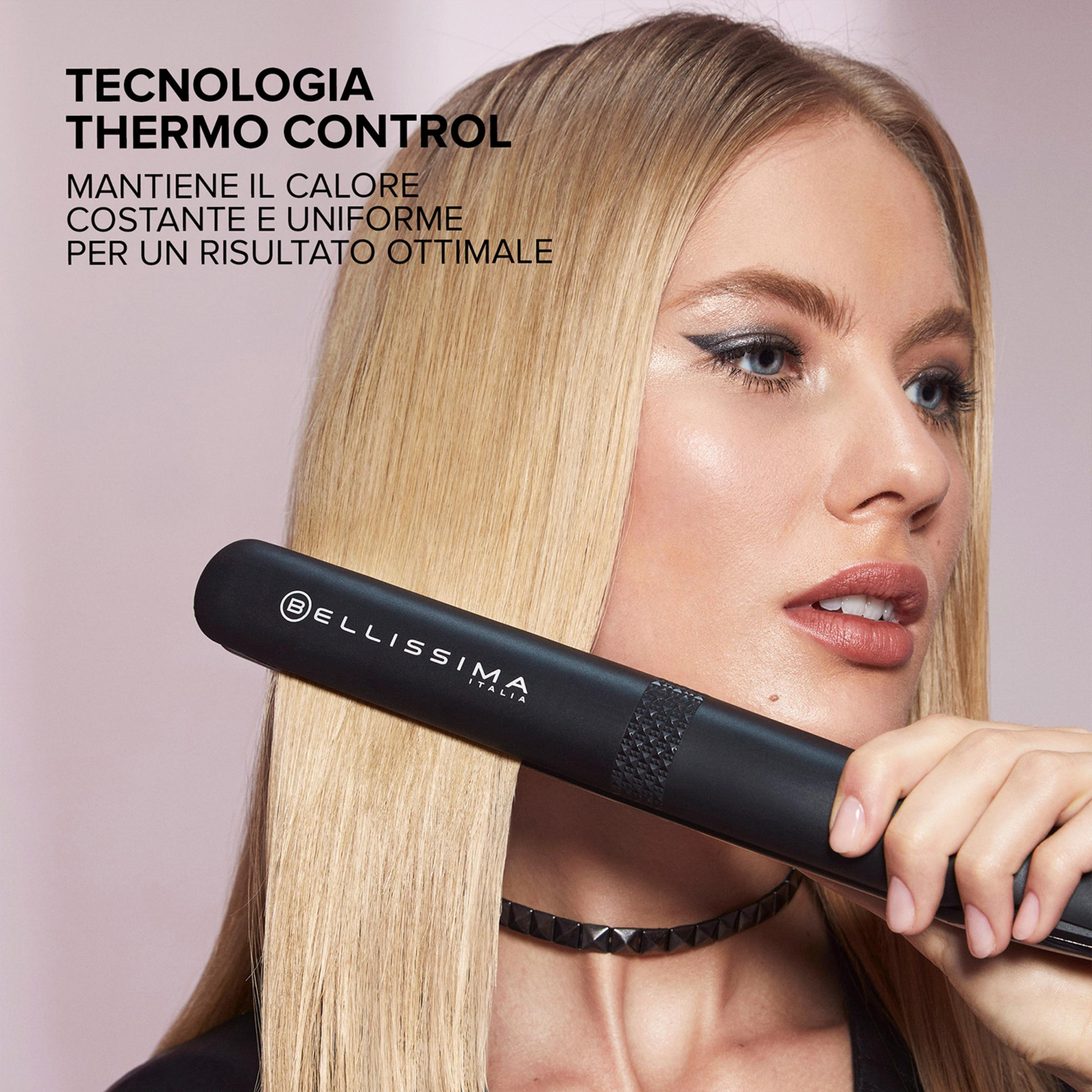 Kobieta z blond włosami prostuje włosy czarną prostownicą.