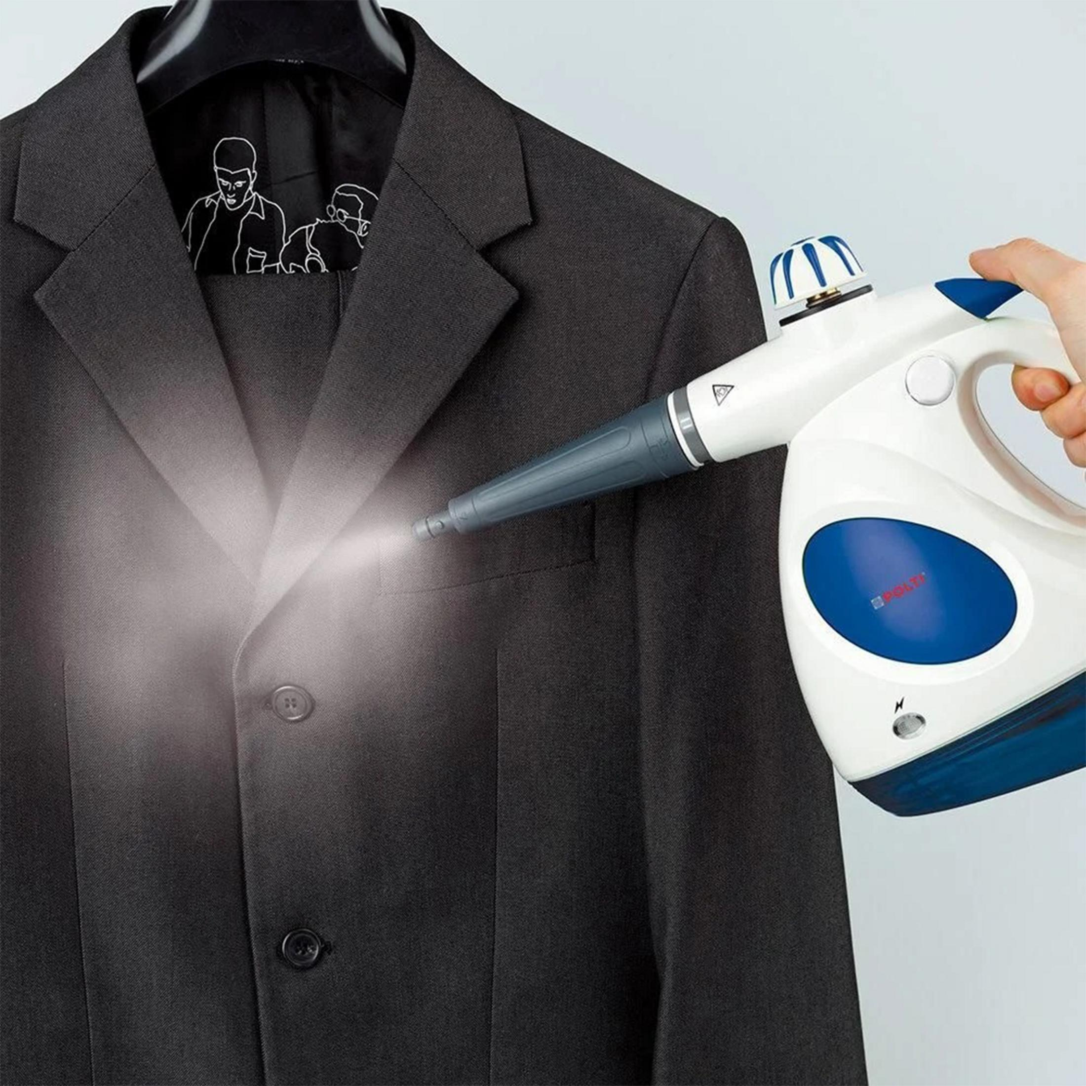 Une main tient un défroisseur, projetant de la vapeur sur une veste de costume sombre.