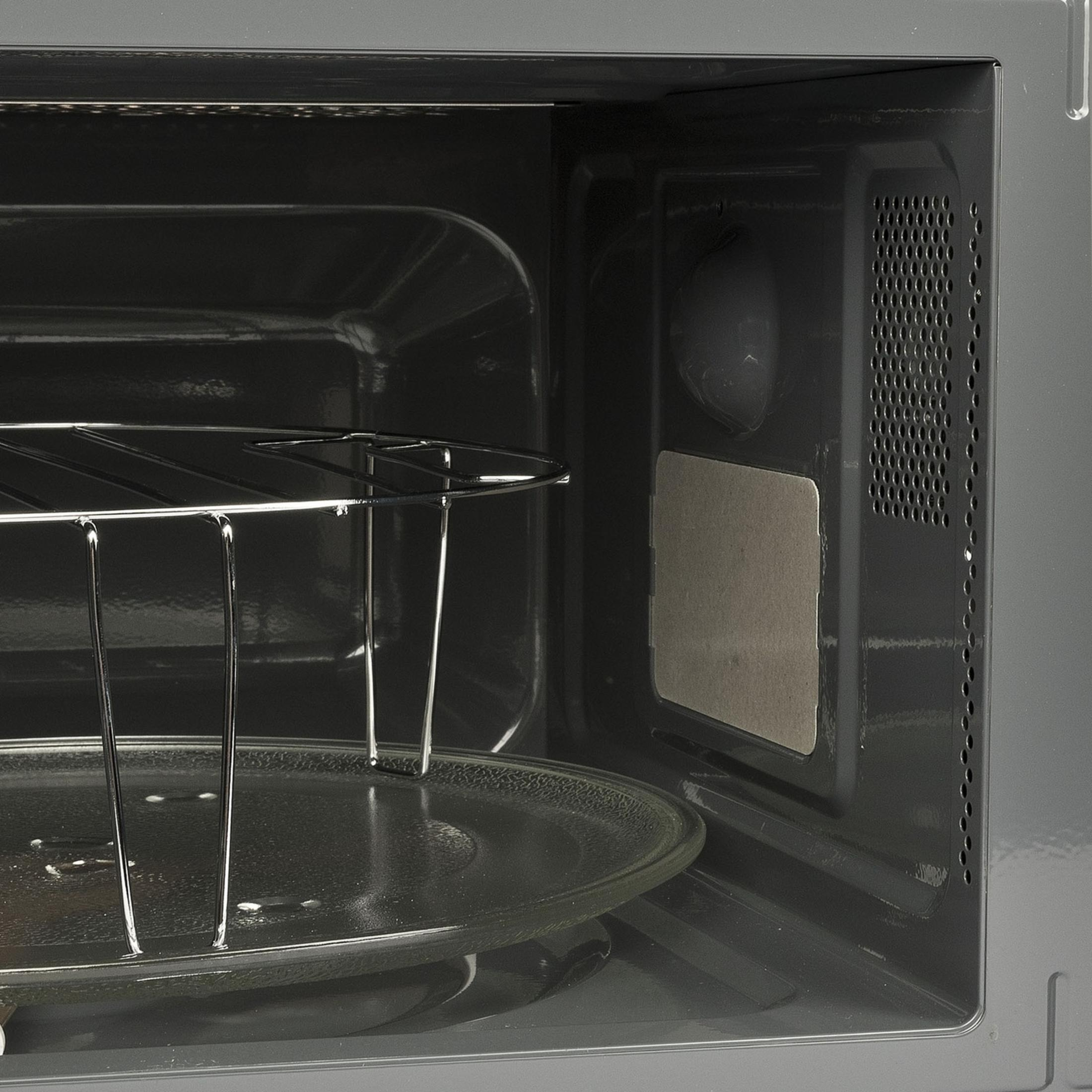 Vista interna di un forno a microonde, con piatto girevole in vetro e griglia.
