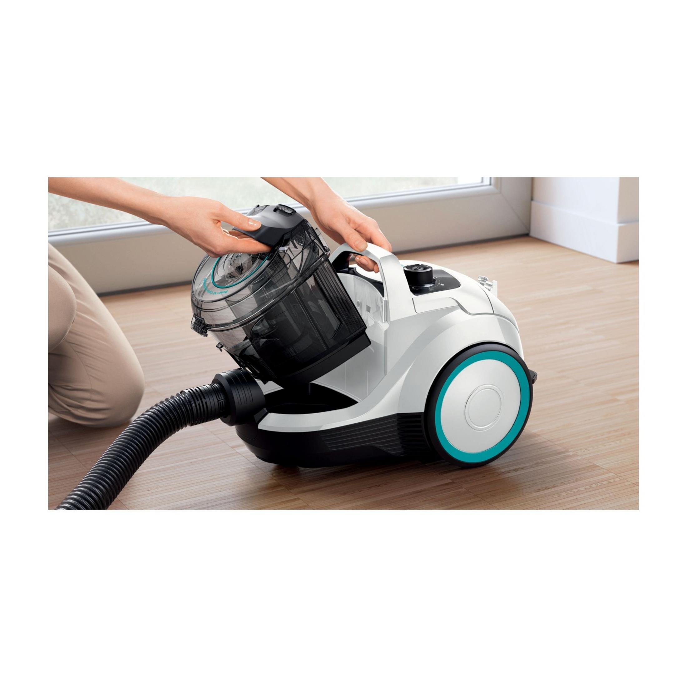 Osoba czyści biały odkurzacz z niebieskim pierścieniem.