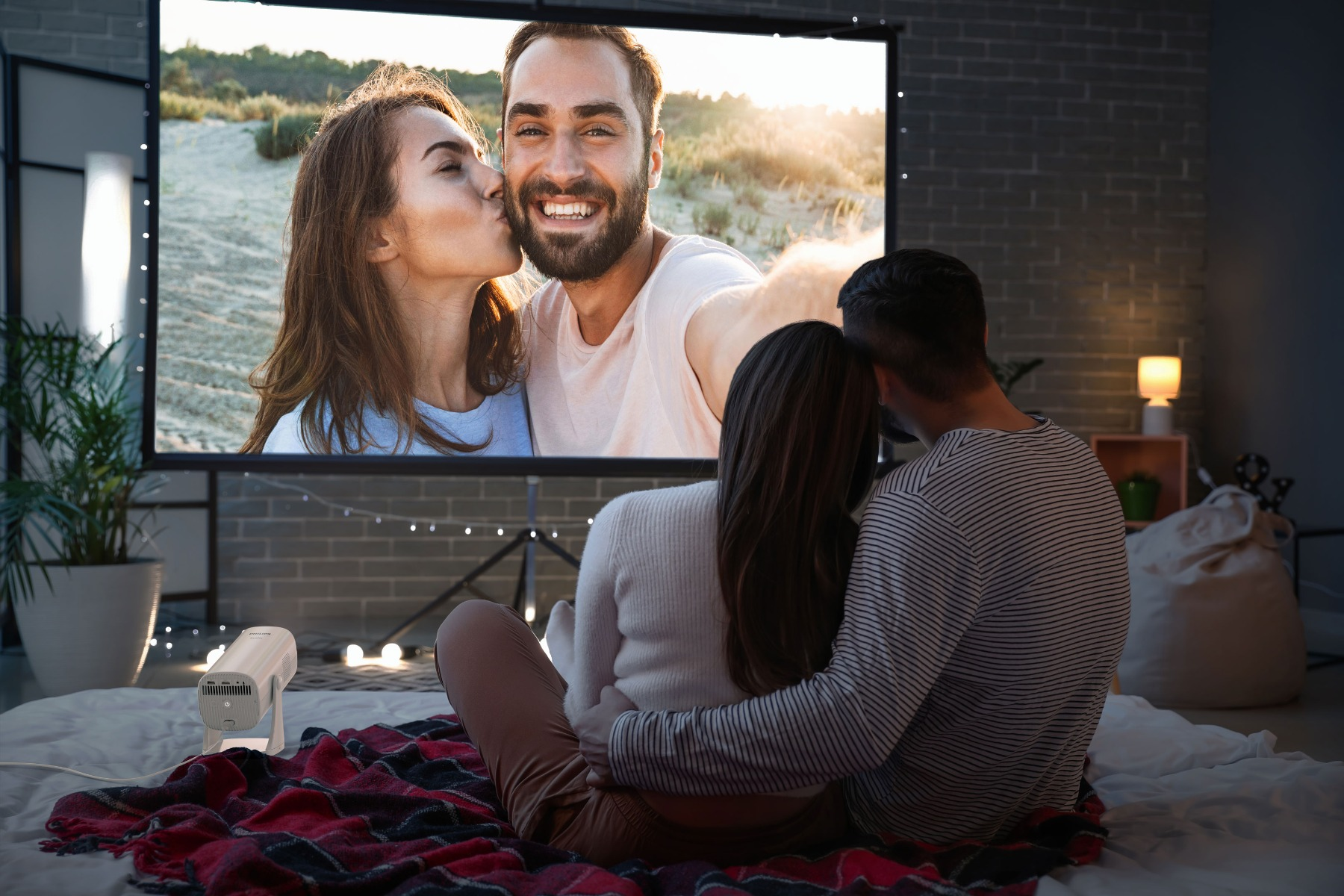 Para ogląda film na projektorze pokazującym kobietę całującą mężczyznę.