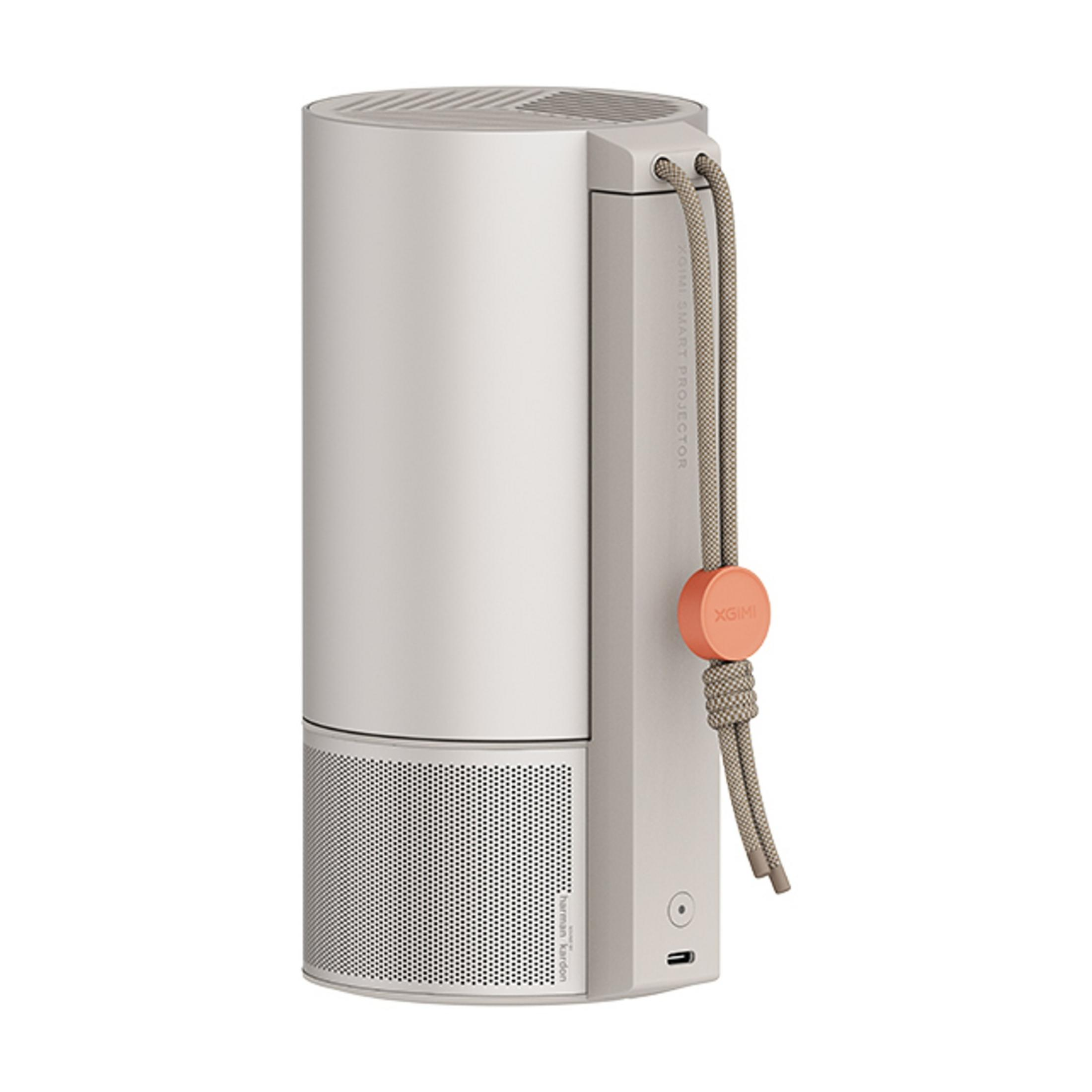 Szary, cylindryczny głośnik z pomarańczową etykietą i sznurkiem.