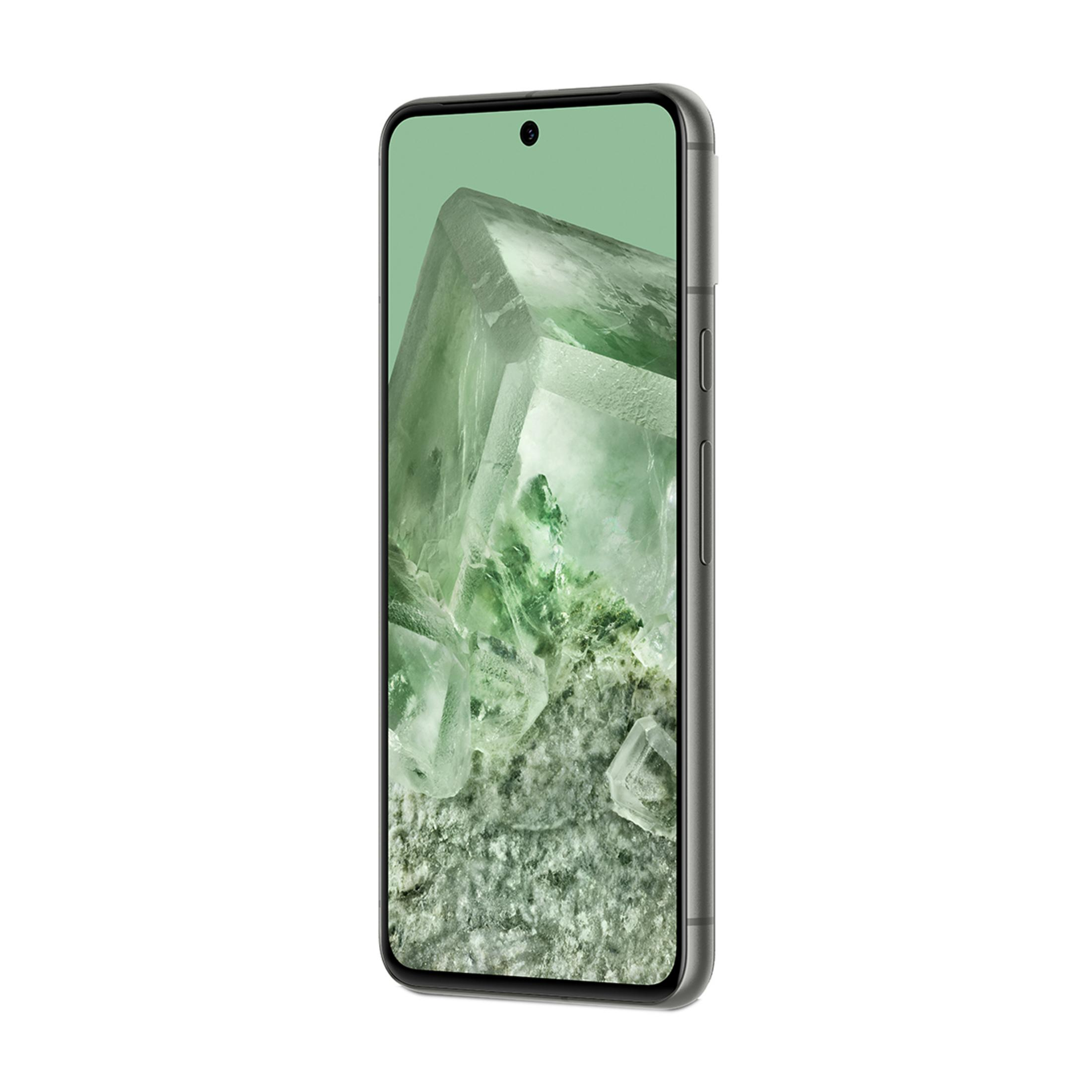 Szary smartfon wyświetlający zielone kryształy na ekranie na białym tle.