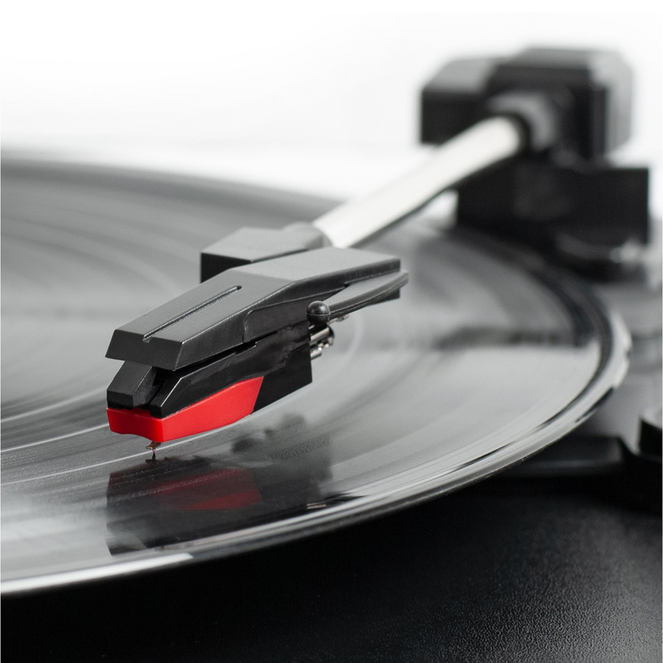 Aguja de tocadiscos con punta roja sobre un disco de vinilo.
