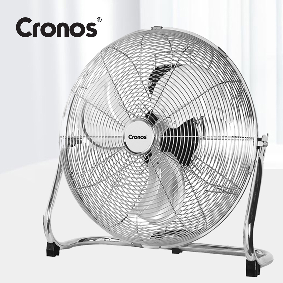 Srebrny wentylator podłogowy Cronos z metalową kratką i łopatkami na jasnym tle.