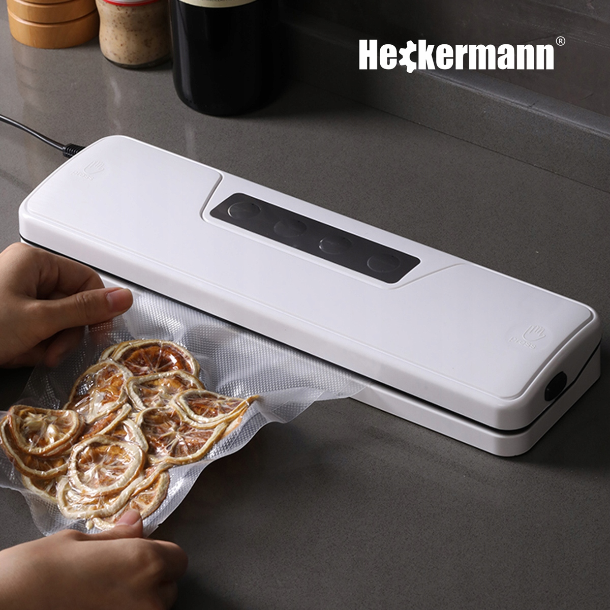 Biała zgrzewarka próżniowa zamyka worek z suszonymi plasterkami pomarańczy.