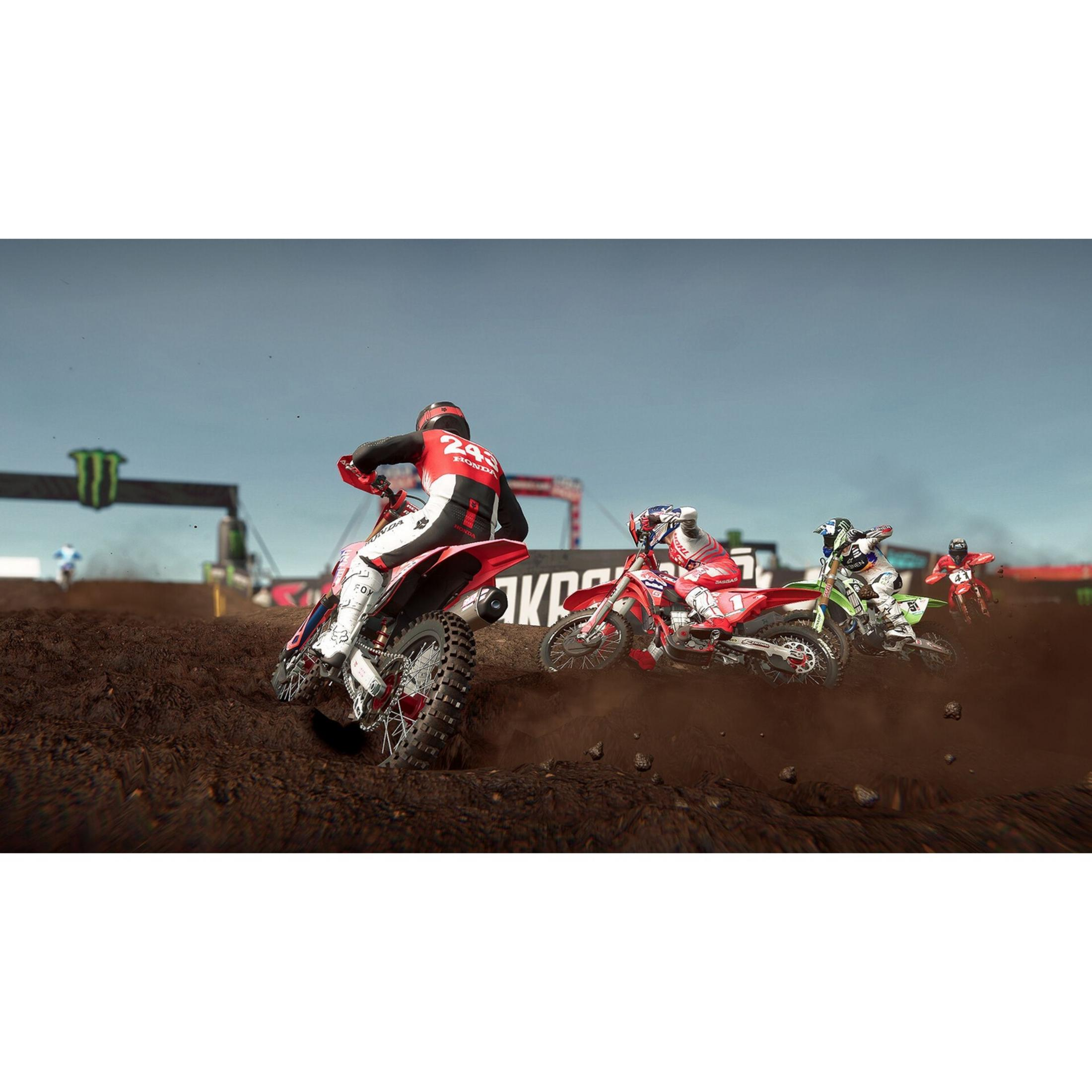 Piloti di motocross su pista sterrata, vestiti di rosso, verde e bianco.