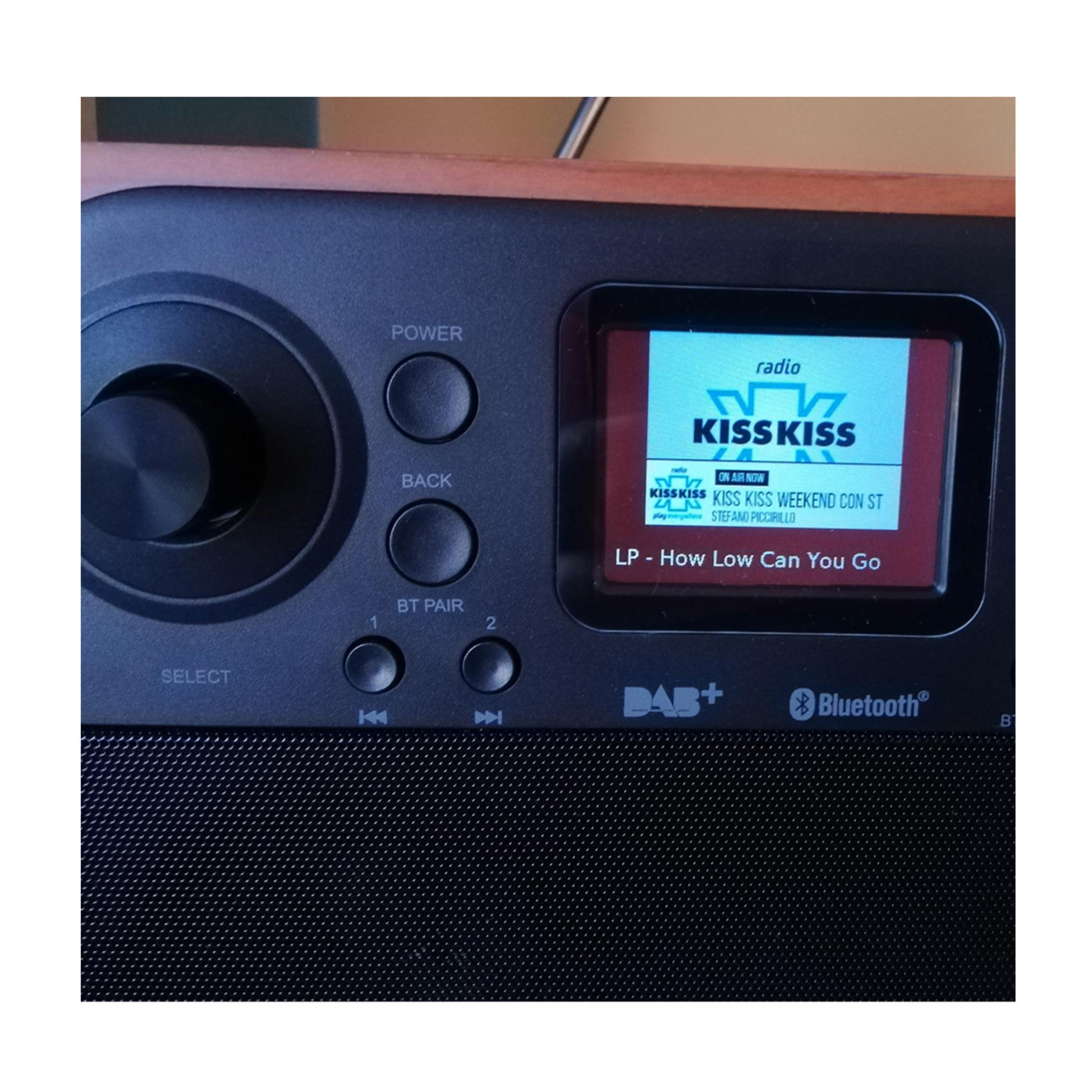 Ein DAB+ Radio mit Holzrahmen, schwarzer Vorderseite und Farbbildschirm.