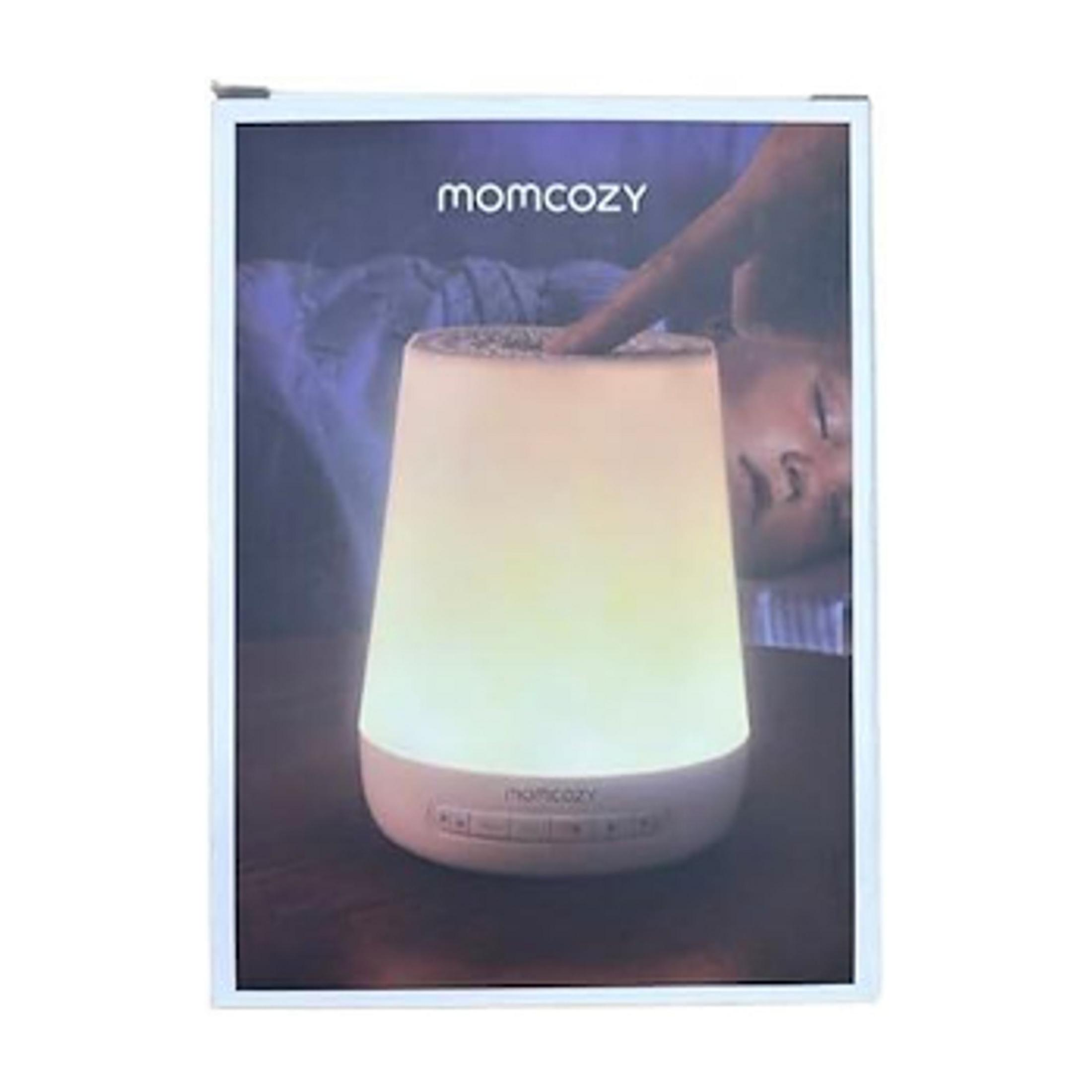Eine Person berührt eine leuchtende Lampe mit dem Momcozy-Logo.
